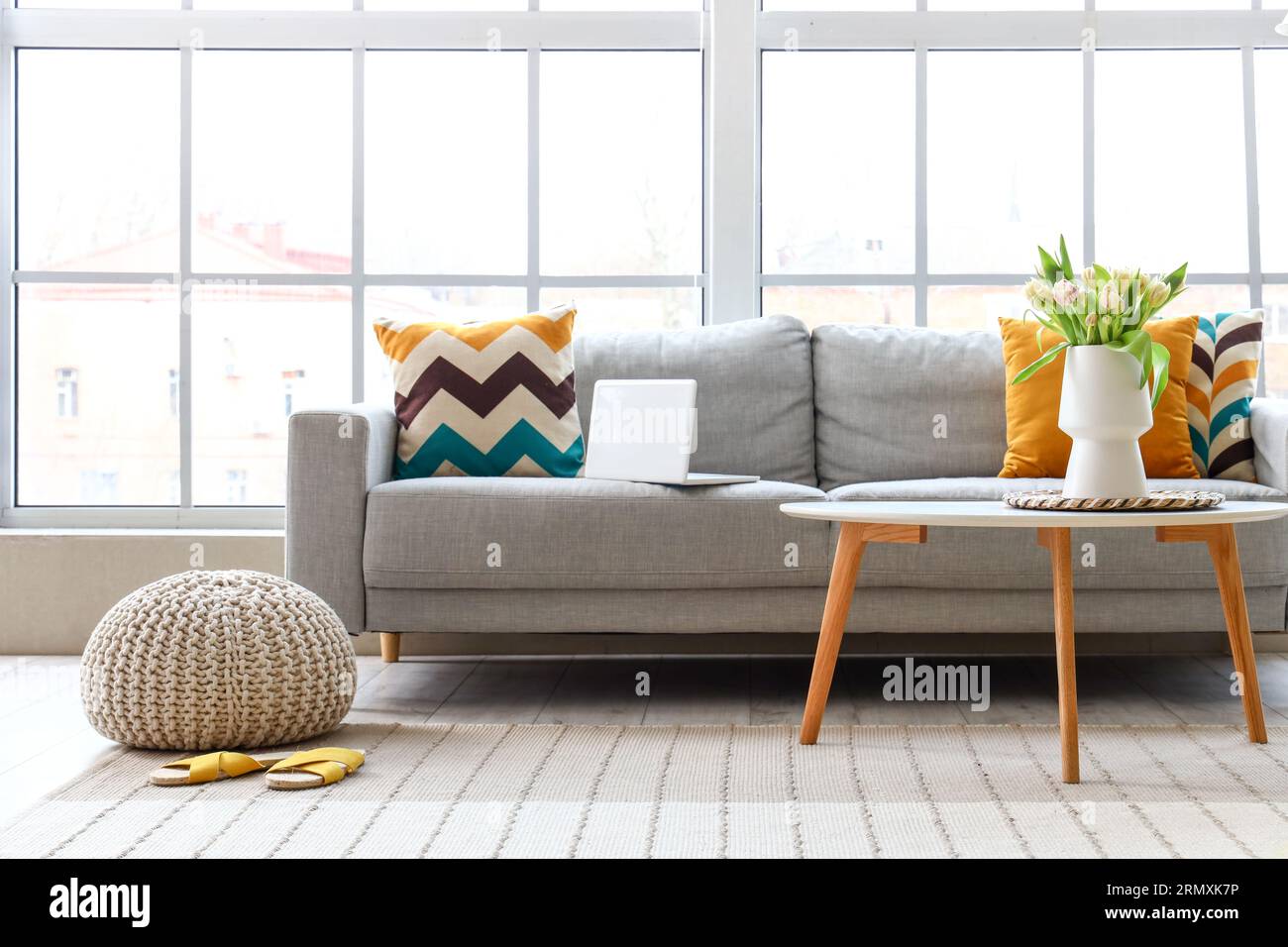 Interior of bright living room with cozy sofa and coffee table near big ...