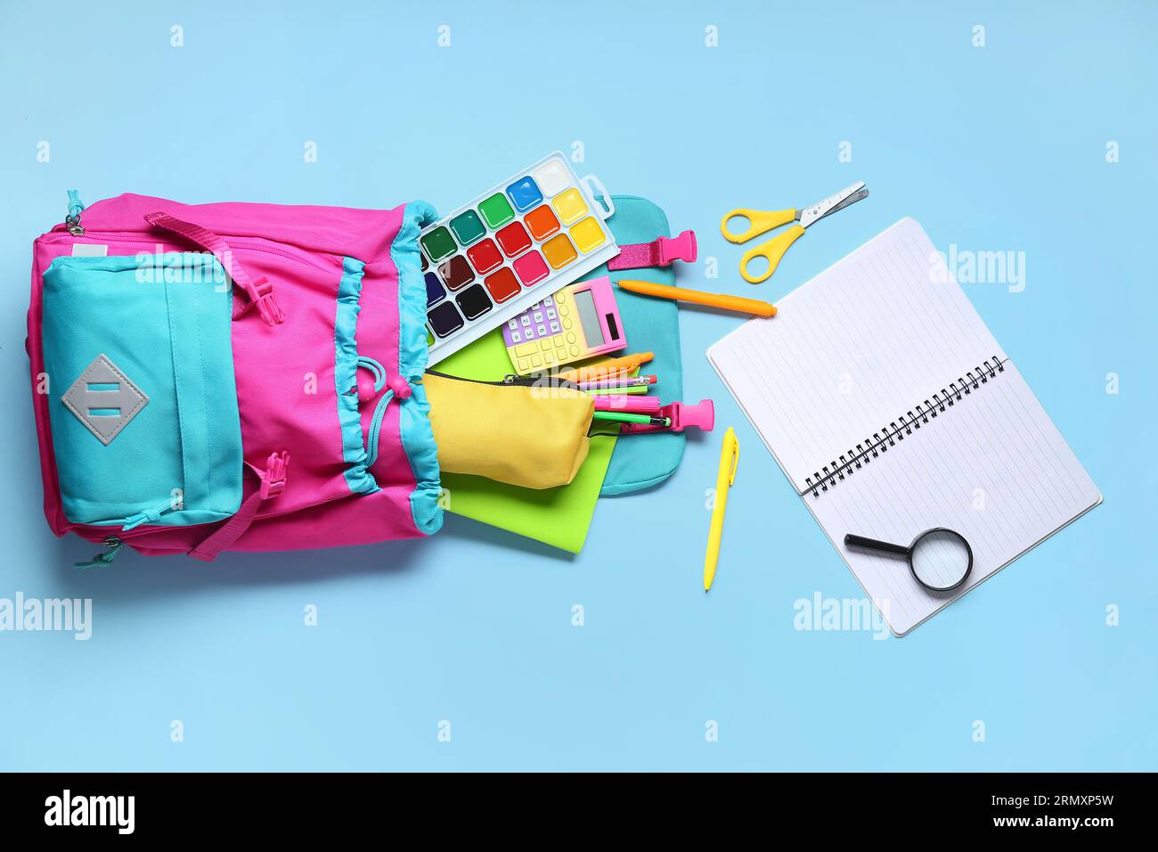 Stylish school backpack with different stationery on blue background Stock Photo