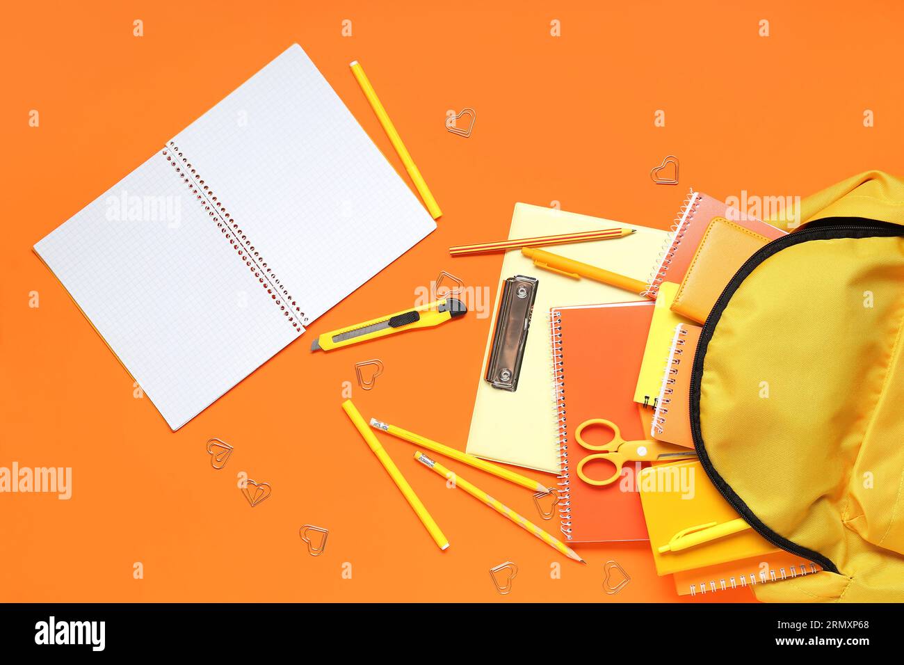 Stylish school backpack and different stationery on orange background Stock Photo