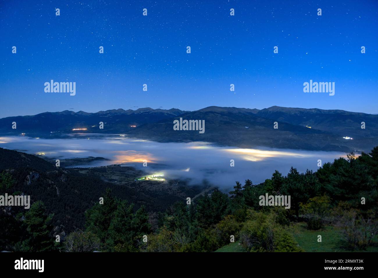 Early morning blue hour with fog in the Cerdanya valley seen from the Cap Ras viewpoint (Pyrenees, Catalonia, Spain) ESP: Hora azul de la madrugada Stock Photo