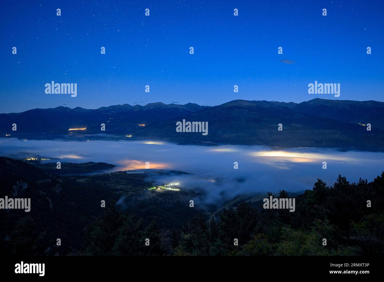 Early morning blue hour with fog in the Cerdanya valley seen from the Cap Ras viewpoint (Pyrenees, Catalonia, Spain) ESP: Hora azul de la madrugada Stock Photo