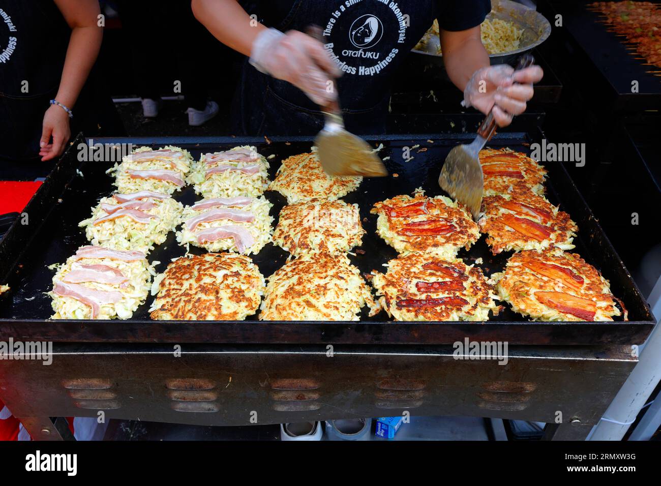 A Osaka-ya grillworker prepares Osaka style Okonomiyaki at Japan Fes food festival street fair on 4th Ave, New York City, 27 August 2023. Stock Photo