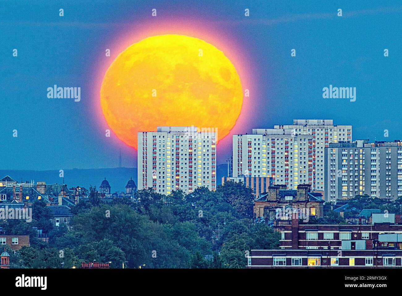 Glasgow, Scotland, UK. 30tht August, 2023. UK Weather:   August Sturgeon Moon supermoon so bright it lights up the hazy night sky over the shy rises of the city centre from the west end. Credit Gerard Ferry/Alamy Live News Stock Photo