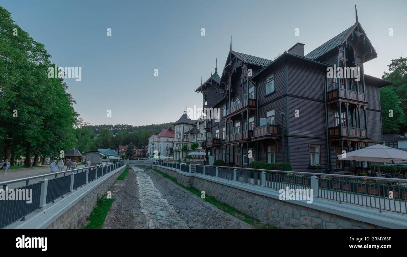 Old wooden houses next to a river in Krynica - Zdroj, a beautiful mountain village in the south of Poland. Summer vibes in malopolska region. Stock Photo