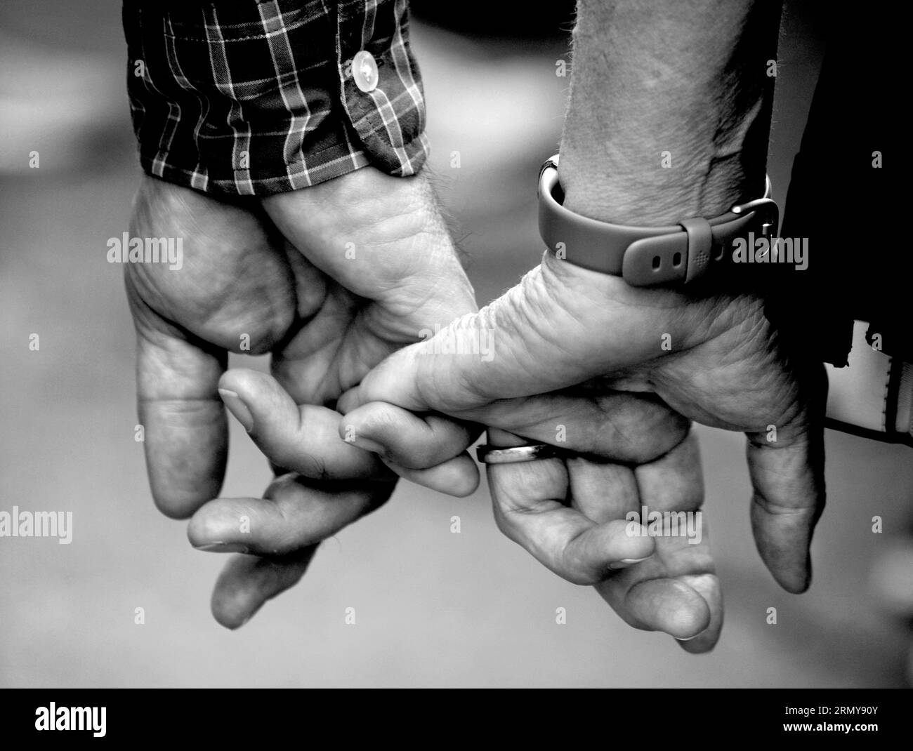 A couple hold hands and interlock fingers as they visit Santa Fe, New Mexico. Stock Photo