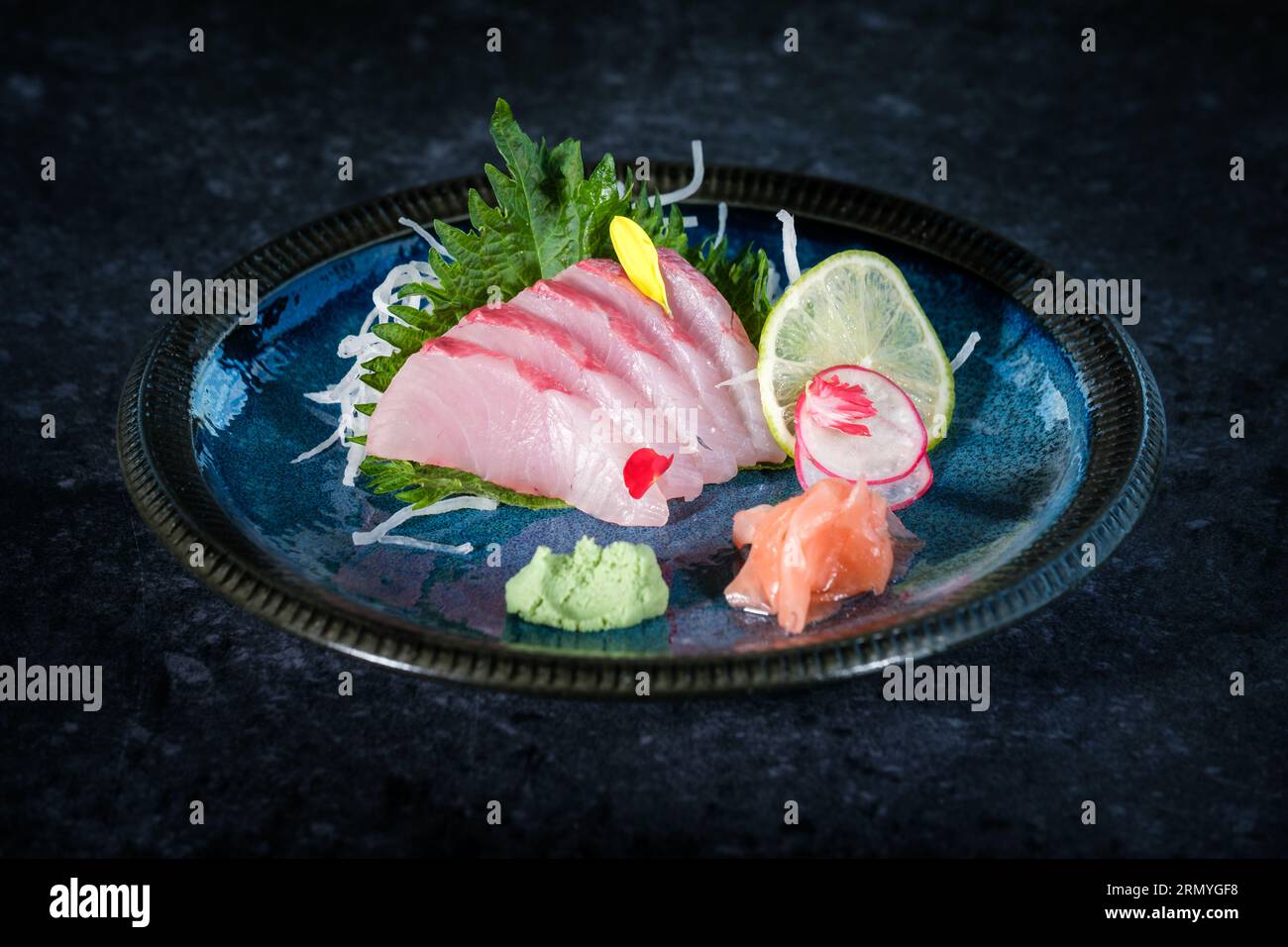 Delicious sashimi of yellowtail fish served on plate with slice of lime and  wasabi with ginger on table in restaurant Stock Photo - Alamy, image size:1300x956