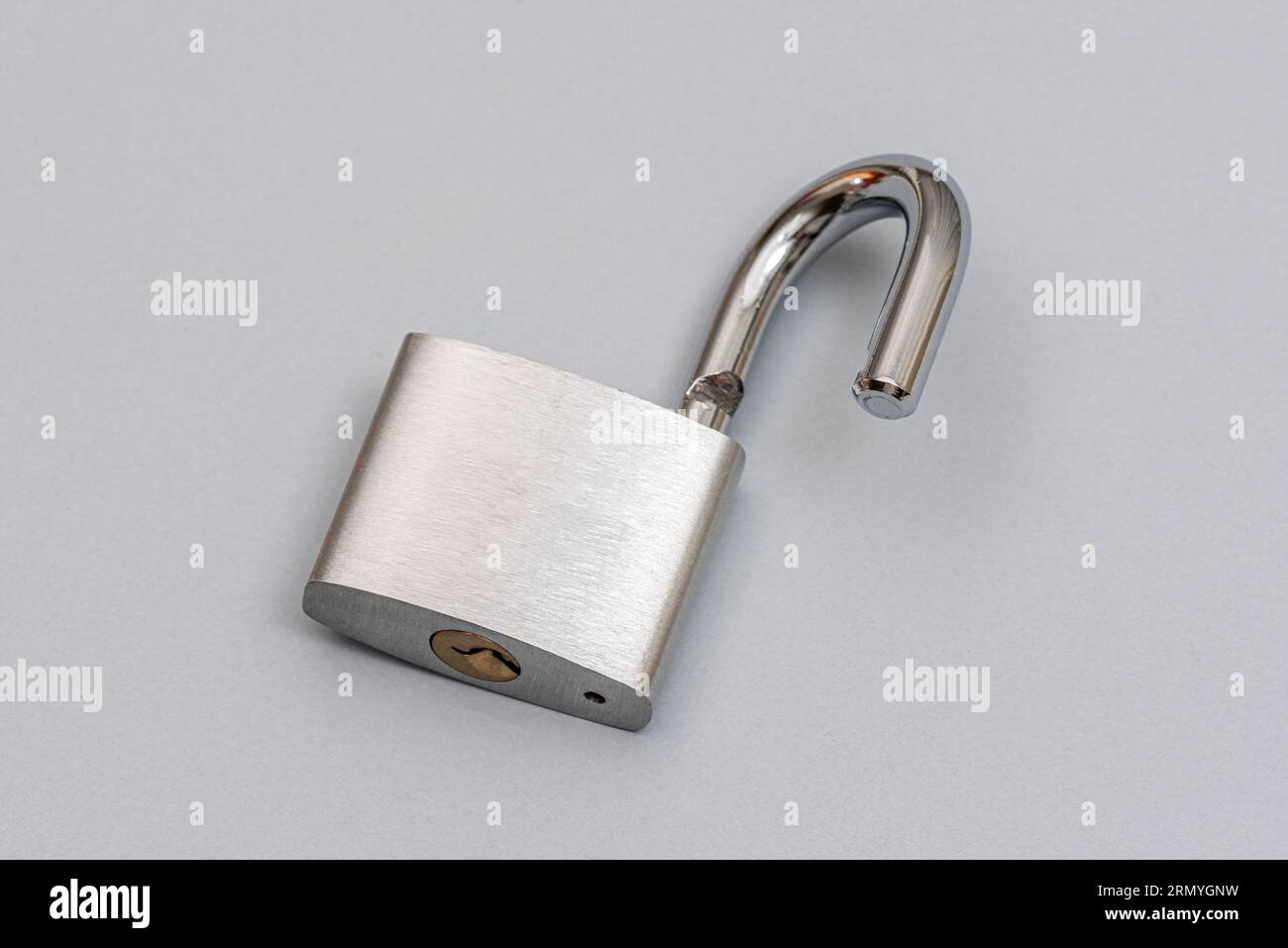 Unlocked silver padlock on the gray background. Stock Photo