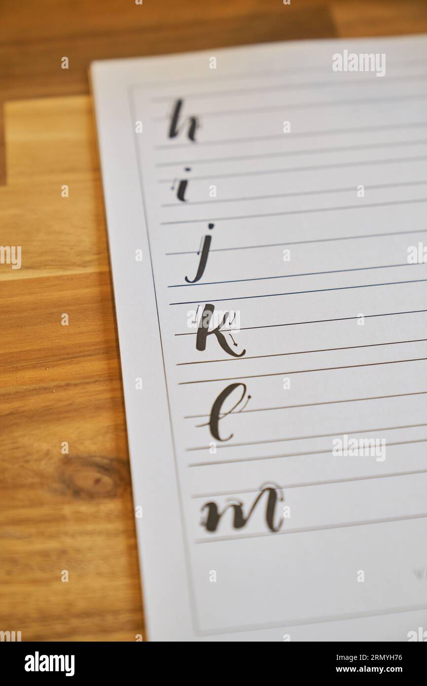 High angle of lined paper sheet with sequence of alphabet letters ...