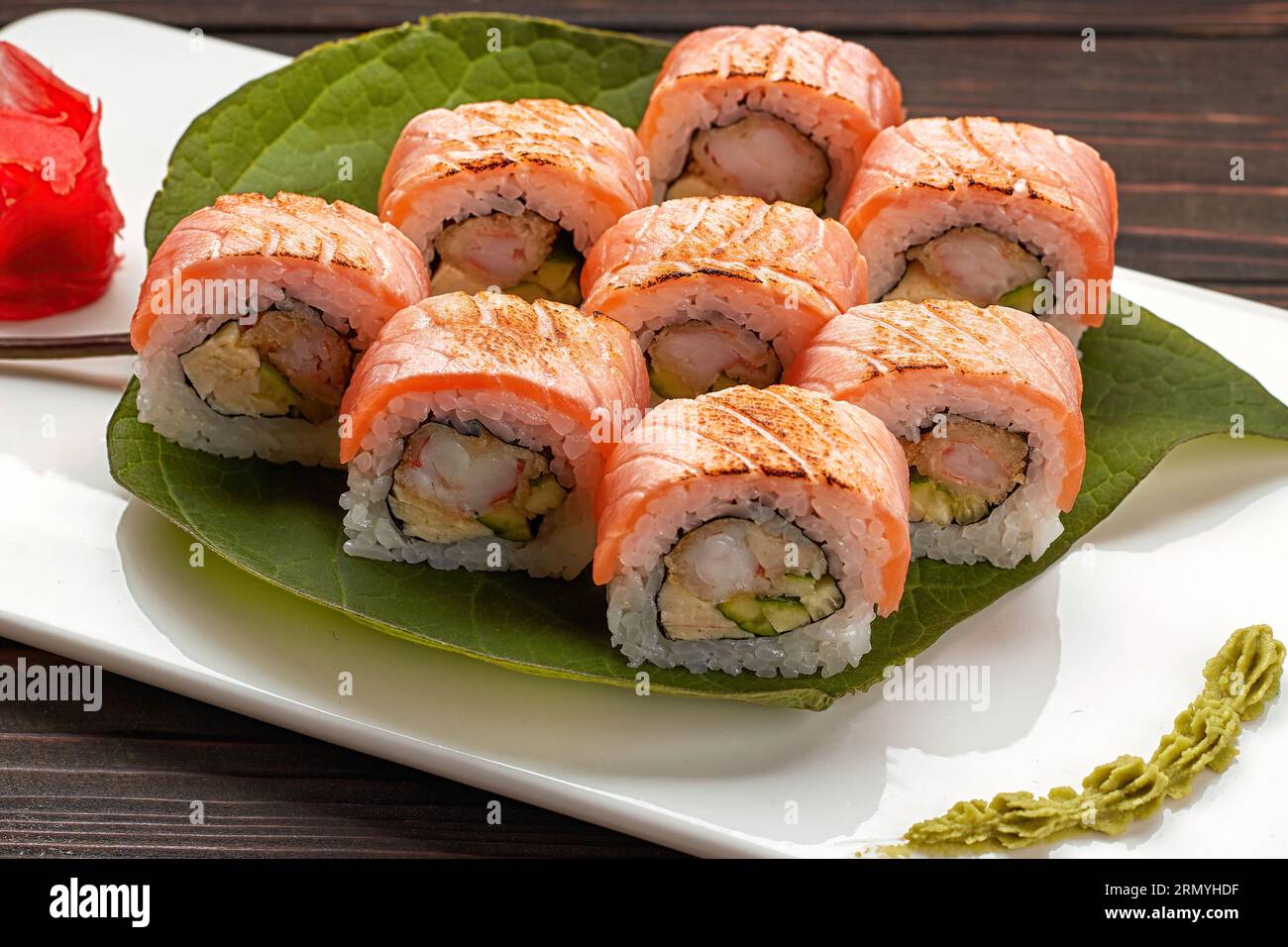 Delicious sushi rolls with wasabi and ginger with chopsticks. Close up Stock Photo