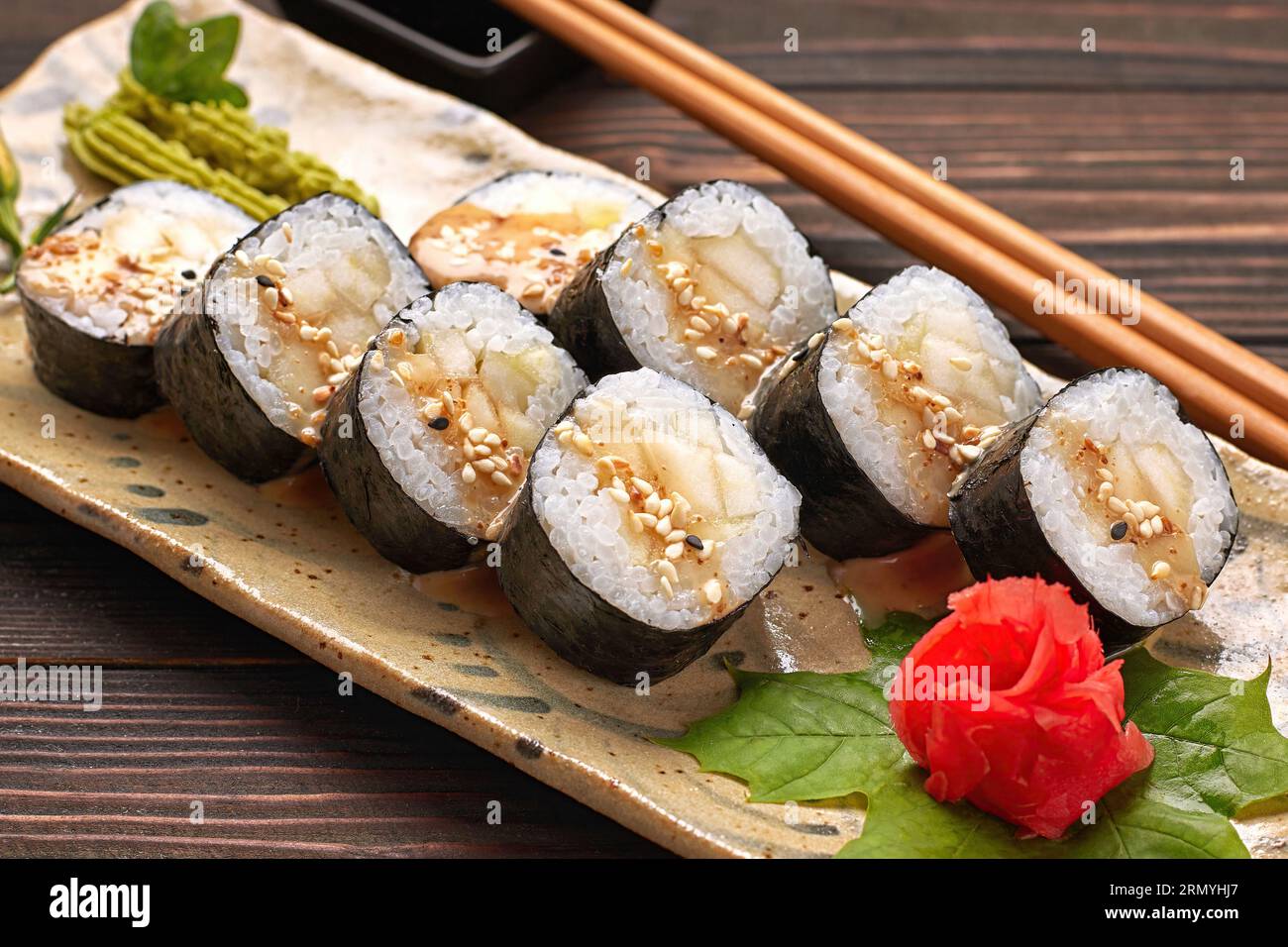 Delicious sushi rolls with wasabi and ginger with chopsticks. Closeup Stock Photo