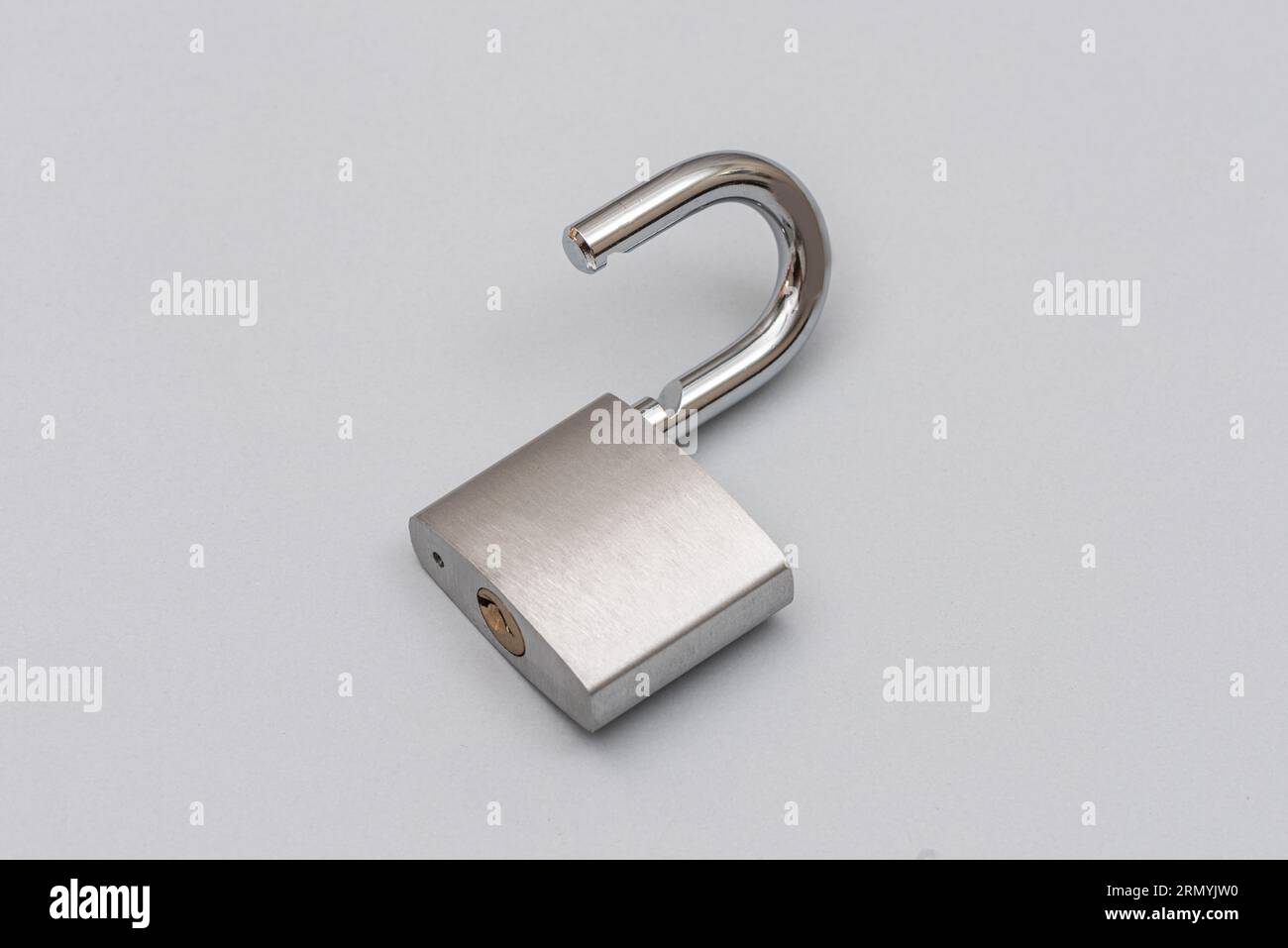 Unlocked silver padlock on the gray background. Stock Photo
