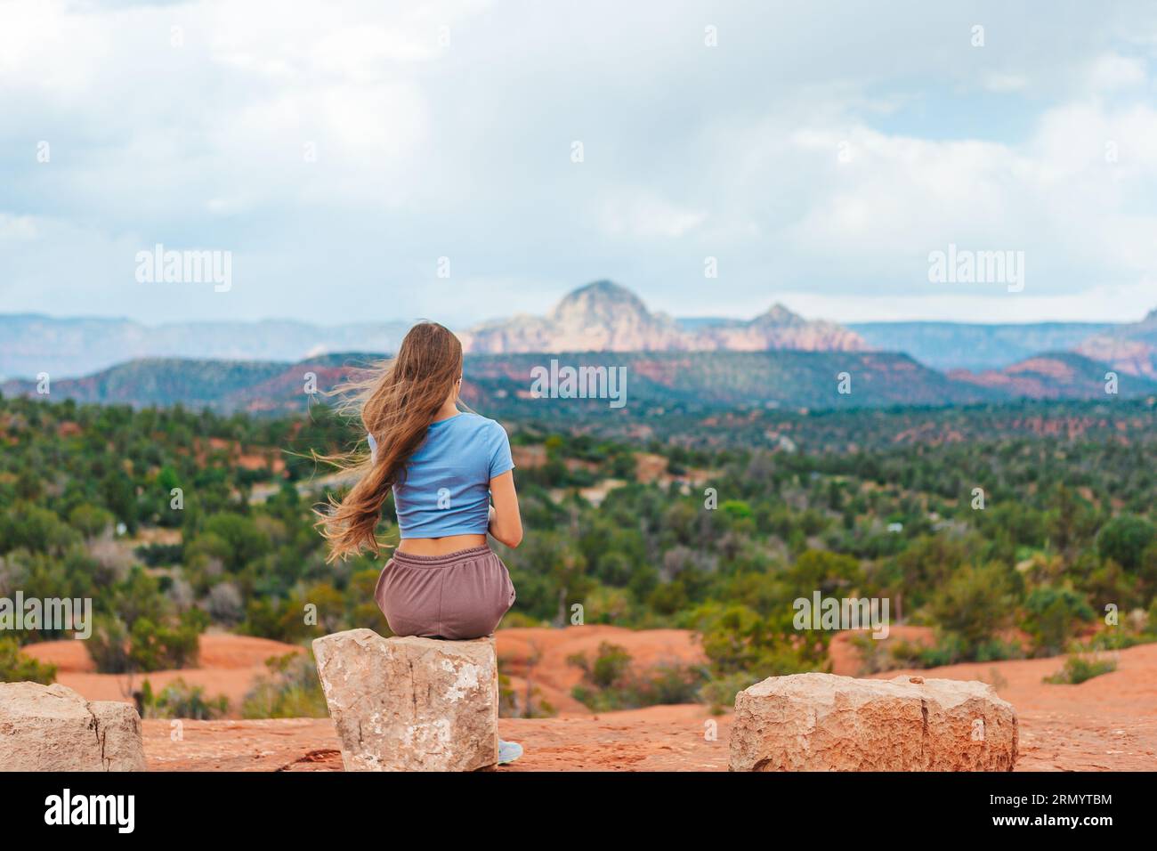 Young hiker on the edge of a cliff at Cathedral Rock in Sedona, Arizona ...