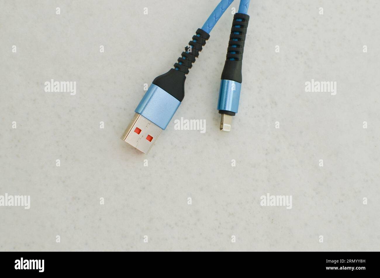 Apple USB cable connection detail highlighted on a light surface, perfect for modern technology concepts. Cable that provides speed and data transfer. Stock Photo