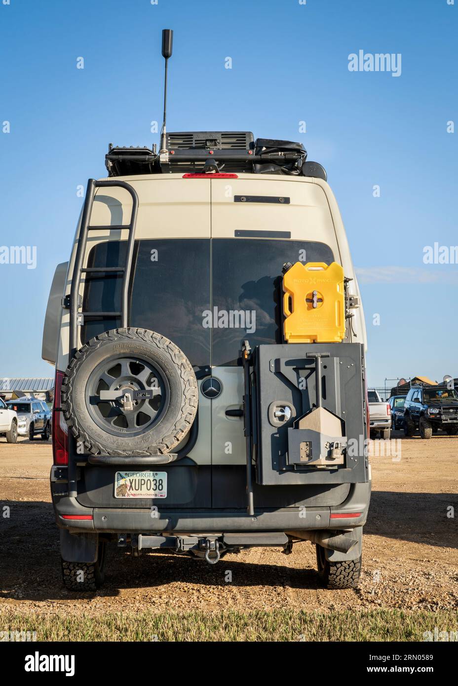 Loveland, CO, USA - August 27, 2023: Back of Mercedes Sprinter 4x4 camper van with a spare tire, roof ladder and rack with different gear attached. Stock Photo