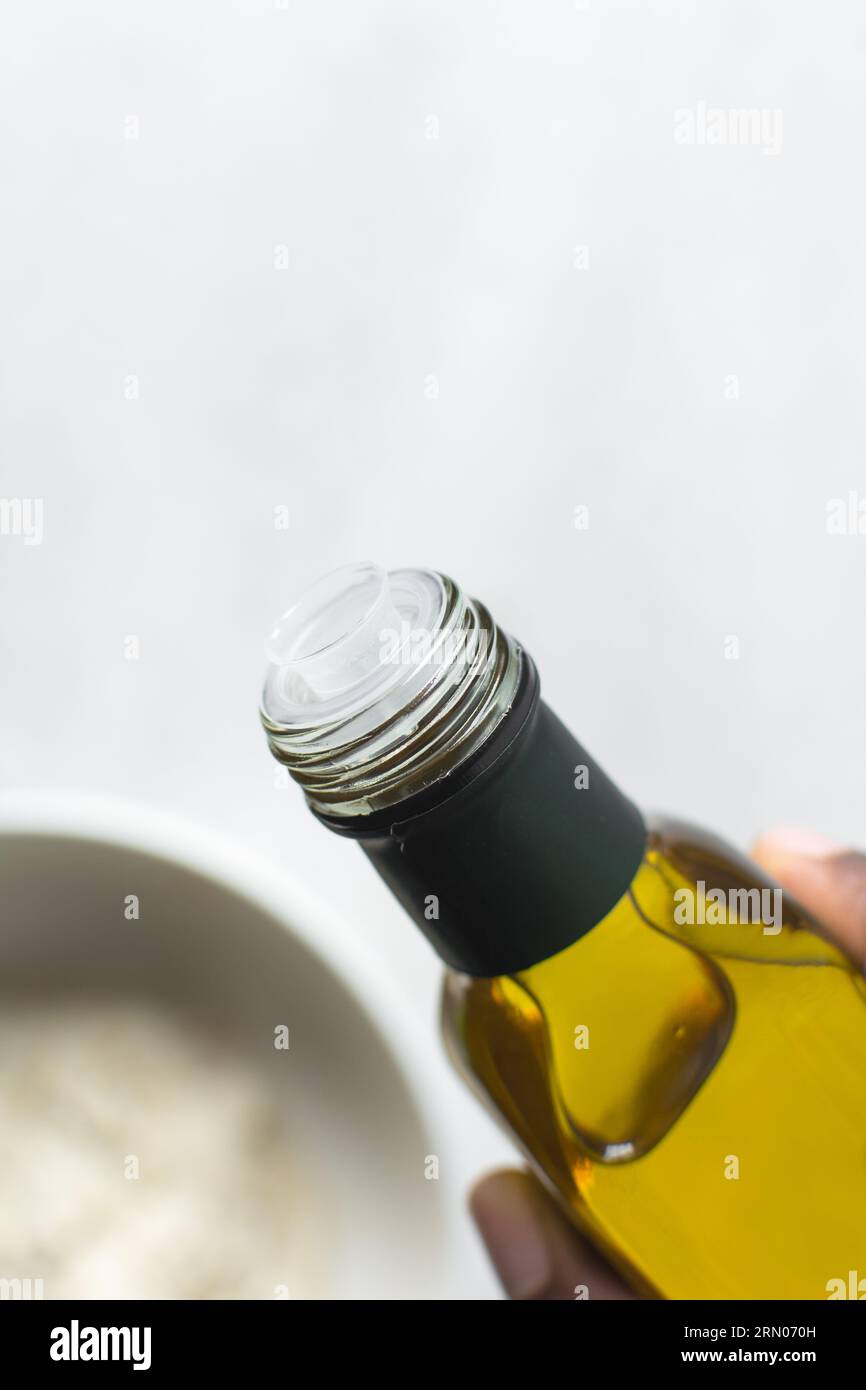 Pouring olive oil into a measuring spoon, measuring a tablespoon of oil
