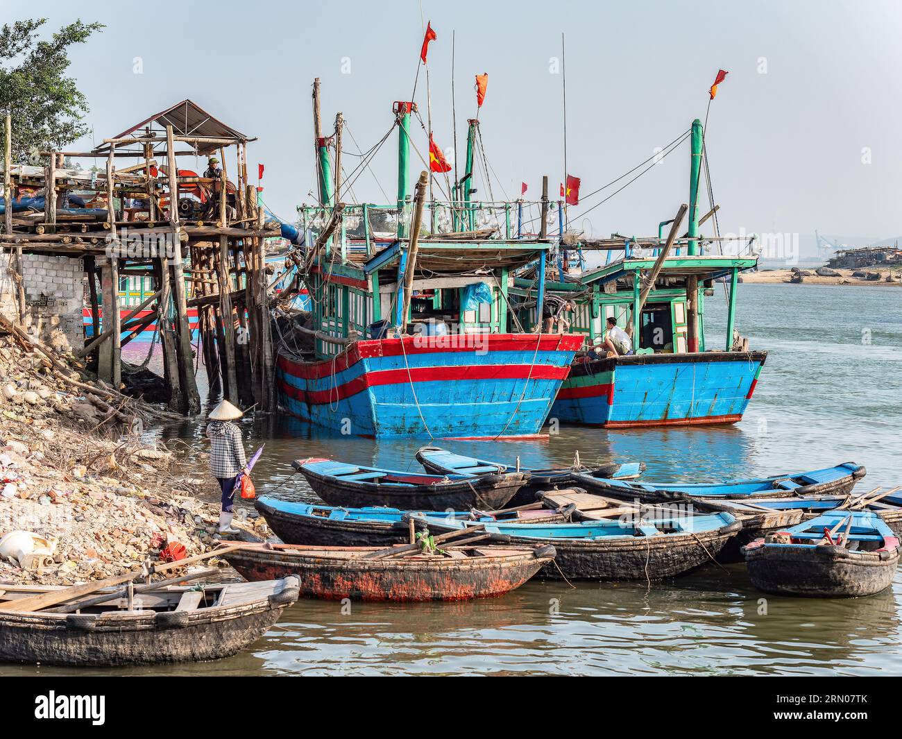 Fishing boats and fishermen at a port in Hai Thanh, a village in the Thanh Hoa province of Vietnam. Stock Photo