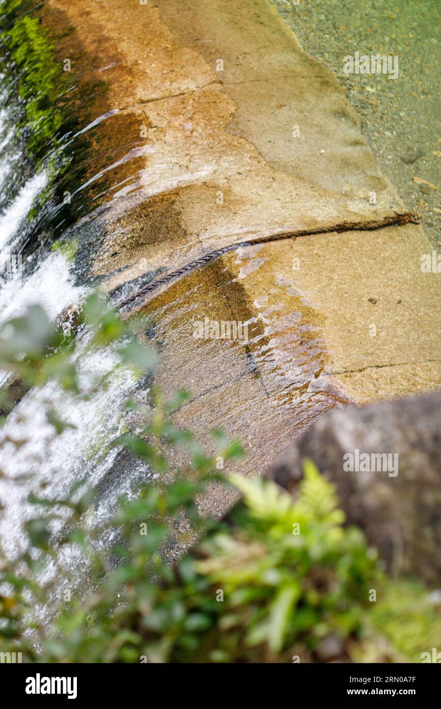 Water flowing over a weir in Upper Hutt New Zealand. A structure that takes a natural river and helps to treat it. Stock Photo