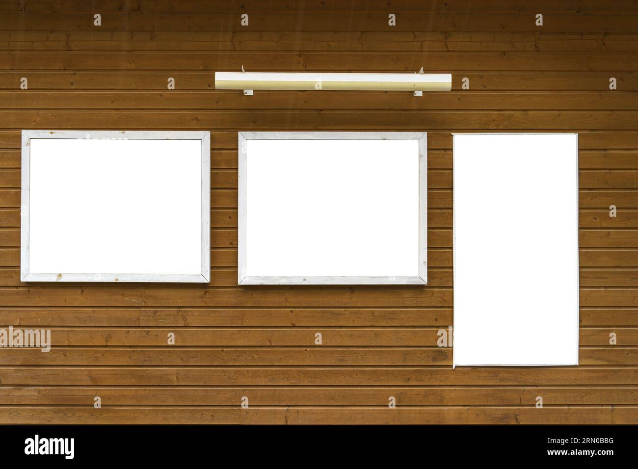 Three empty white bulletin boards on a wooden wall. Stock Photo
