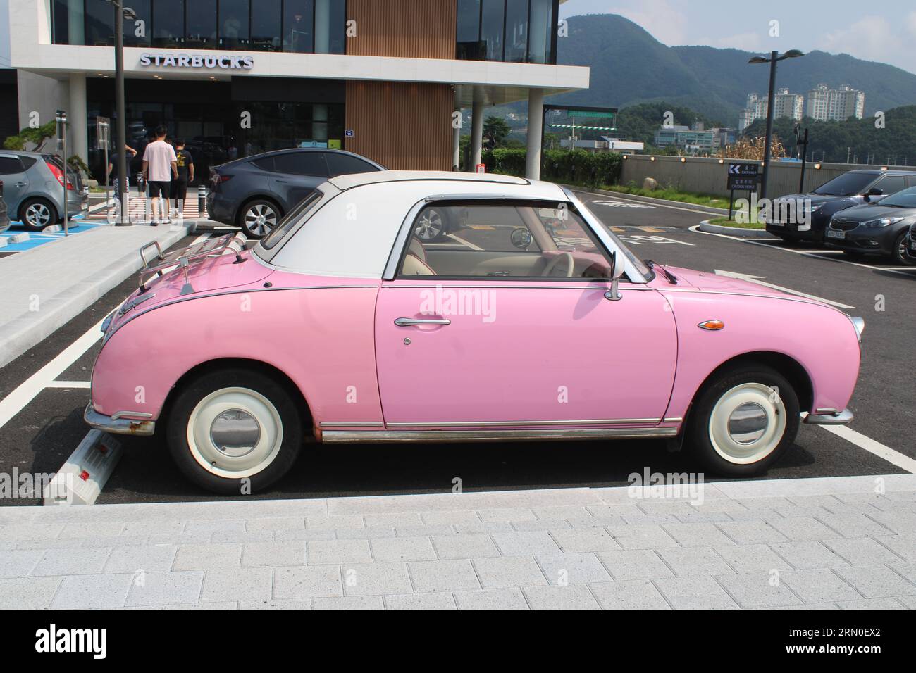 Side view of vintage pink car in parking lot Stock Photo Alamy