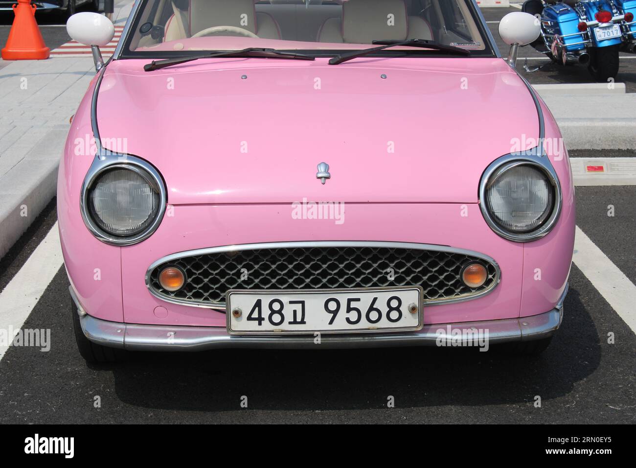 Front view of vintage pink car in parking lot Stock Photo