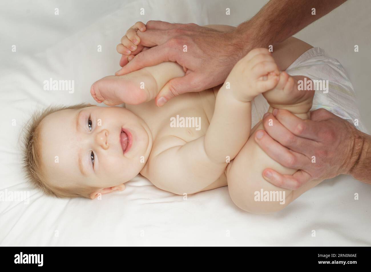Smiling kid lying, playing, wearing diaper at home. Stock Photo