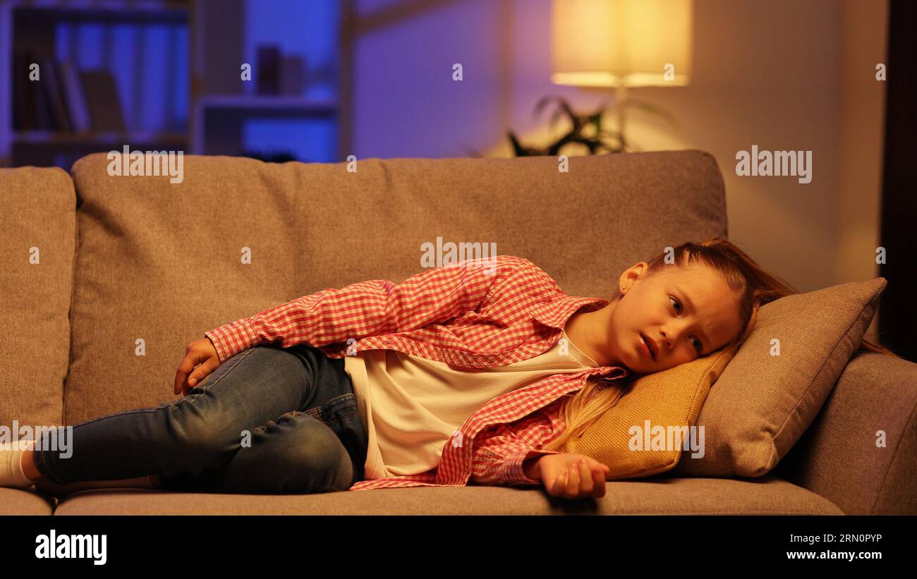Tired little girl slumps on couch feeling listless Feeling depressed