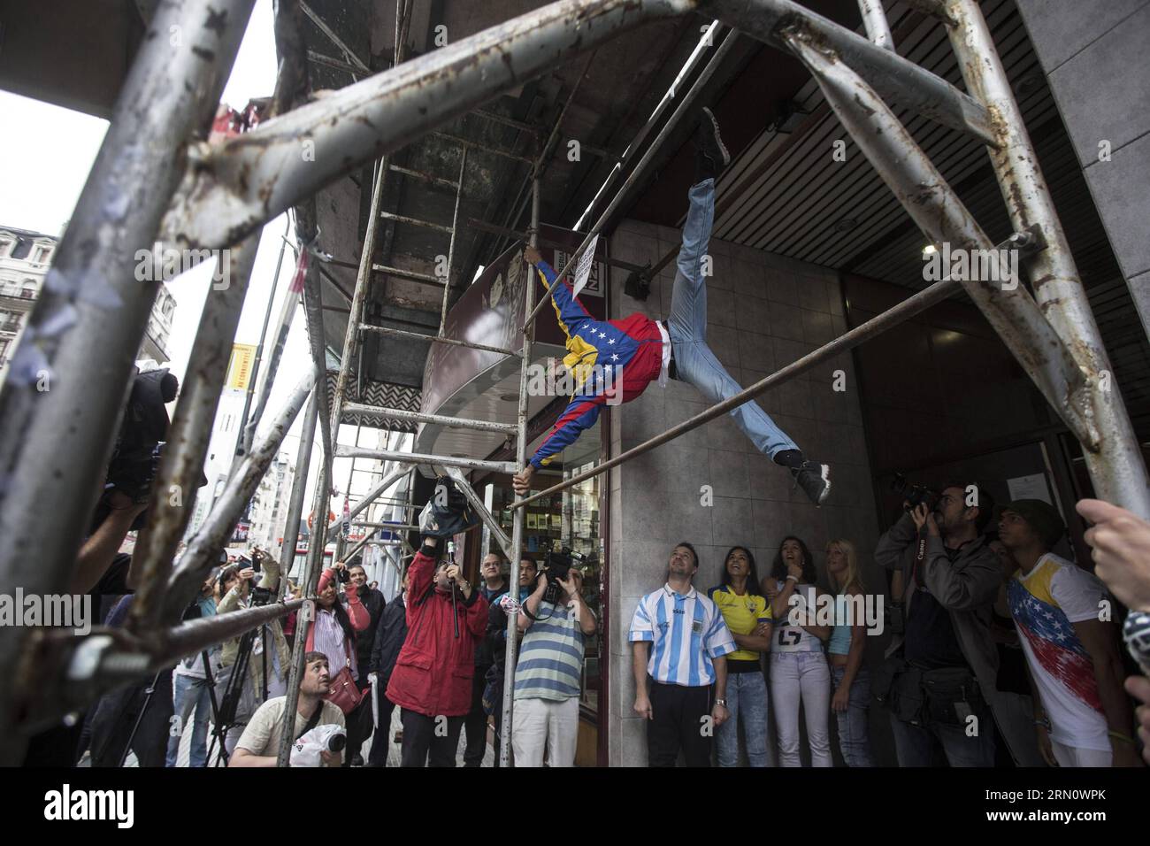 A pole dancer shows his skills on scaffoldings in a street in Buenos