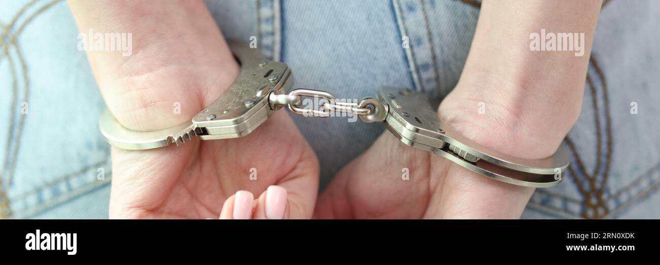 Arrested woman with hands in handcuffs behind back Stock Photo
