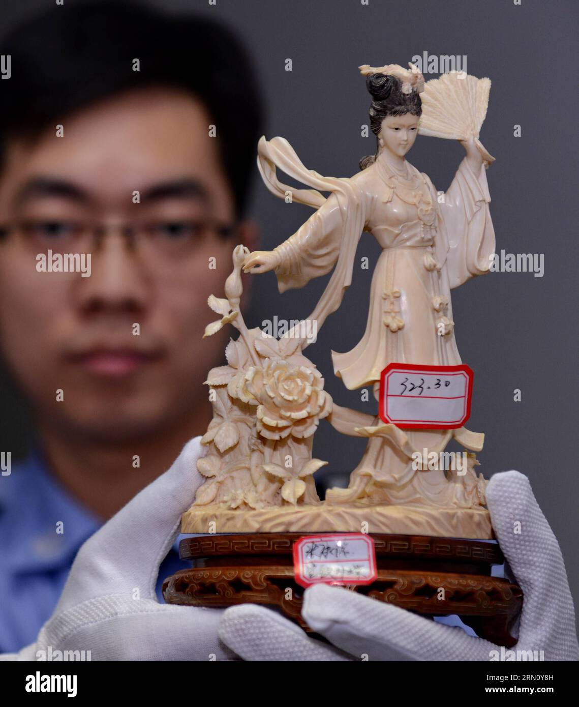 (141127) -- FUZHOU, Nov. 27, 2014 -- A police officer demonstrates an ivory sculpture seized from a group of wildlife smuggling suspects at the local customs of Fuzhou, capital of southeast China s Fujian Province, Nov. 27, 2014. ) (lmm) CHINA-FUJIAN-ILLEGAL TRAFFICKING-SEIZURE (CN) ZhangxGuojun PUBLICATIONxNOTxINxCHN   Fuzhou Nov 27 2014 a Police Officer demonstrates to Ivory Sculpture seized from a Group of Wildlife smuggling suspects AT The Local Customs of Fuzhou Capital of South East China S Fujian Province Nov 27 2014 lmm China Fujian illegal Trafficking Seizure CN ZhangxGuojun PUBLICATI Stock Photo