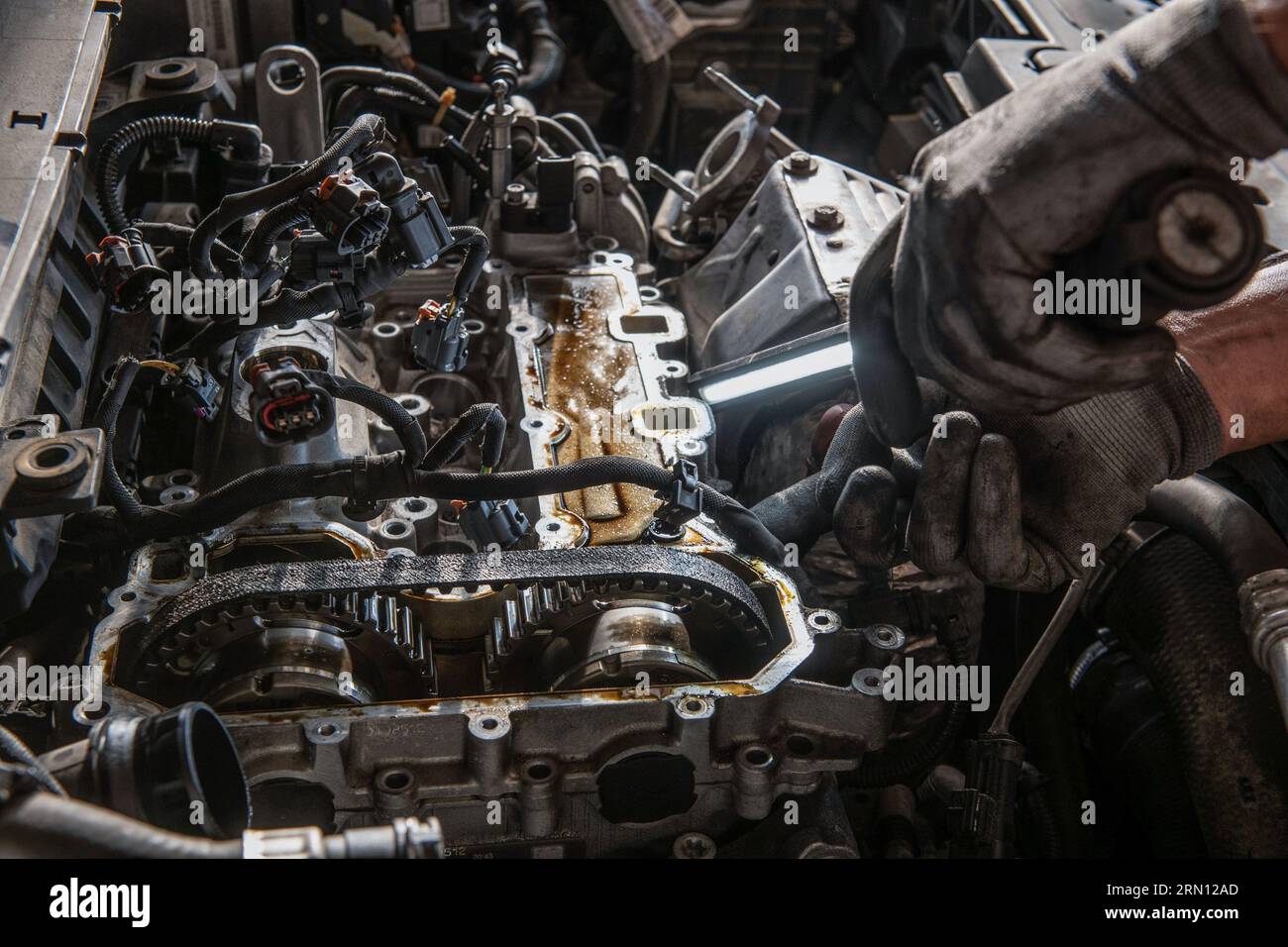 Mechanic working in a garage. Engine, timing belt Stock Photo