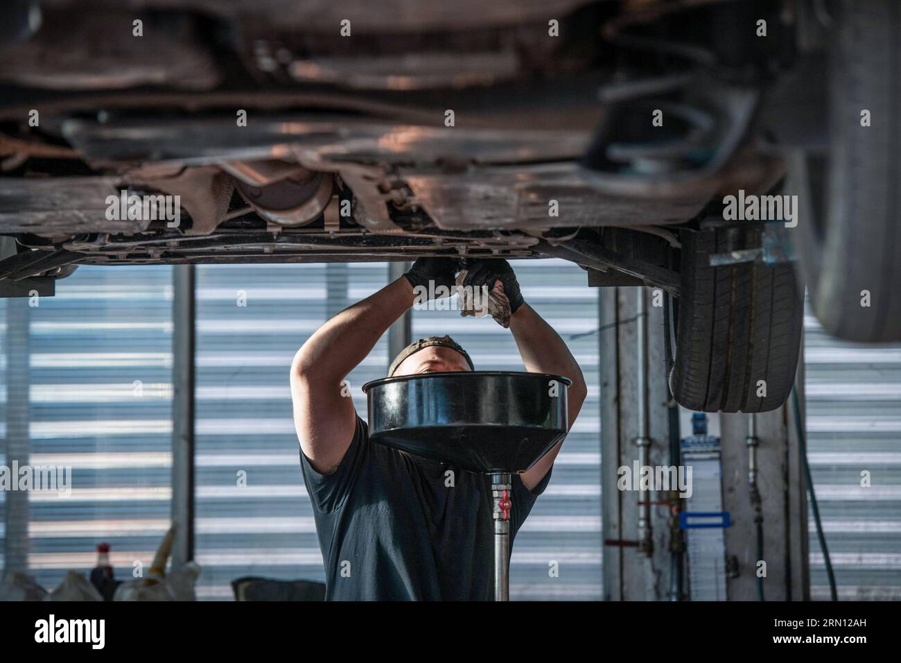 Oil change in a garage, used motor oil Stock Photo