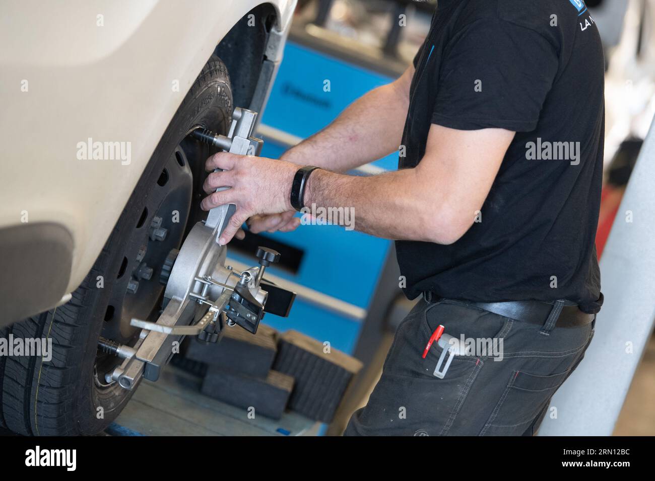 Wheel alignment by a mechanic in a garage Stock Photo