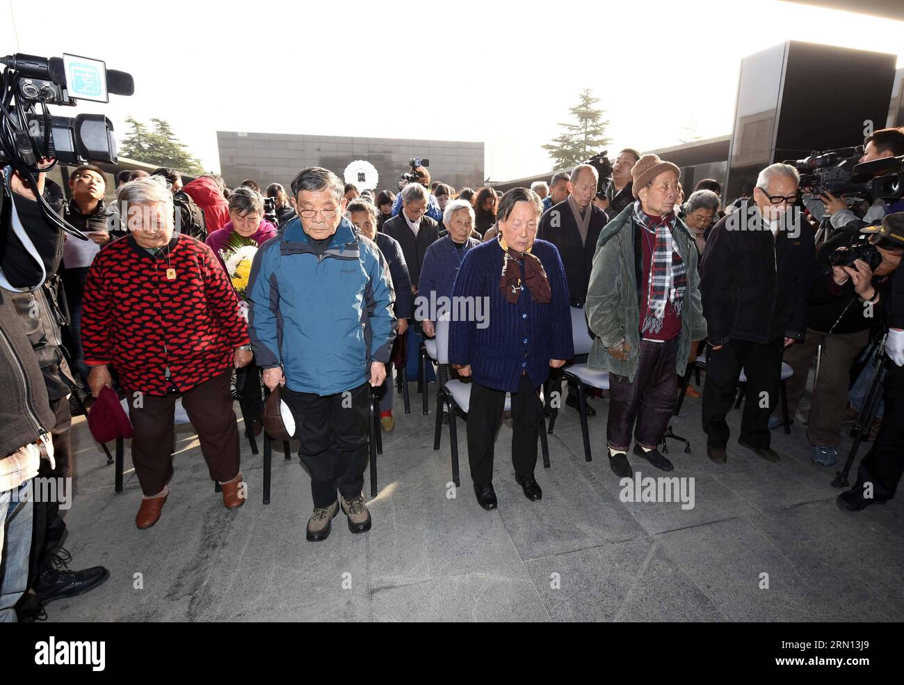 Survivors of the Nanjing Massacre and their family members mourn in front of a wall with List of Nanjing Massacre Victims in 30 Families at the Memorial Hall of the Victims in Nanjing Massacre by Japanese Invaders in Nanjing, capital of east China s Jiangsu Province, Dec. 1, 2014. A series of ceremonies were held by people to mourn their family members killed in the 1937 massacre ahead of the National Memorial Day for Nanjing Massacre Victims, which falls on Dec. 13. ) (ry) CHINA-NANJING-MASSACRE-MEMORIAL CEREMONIES (CN) SunxCan PUBLICATIONxNOTxINxCHN   Survivors of The Nanjing Massacre and th Stock Photo