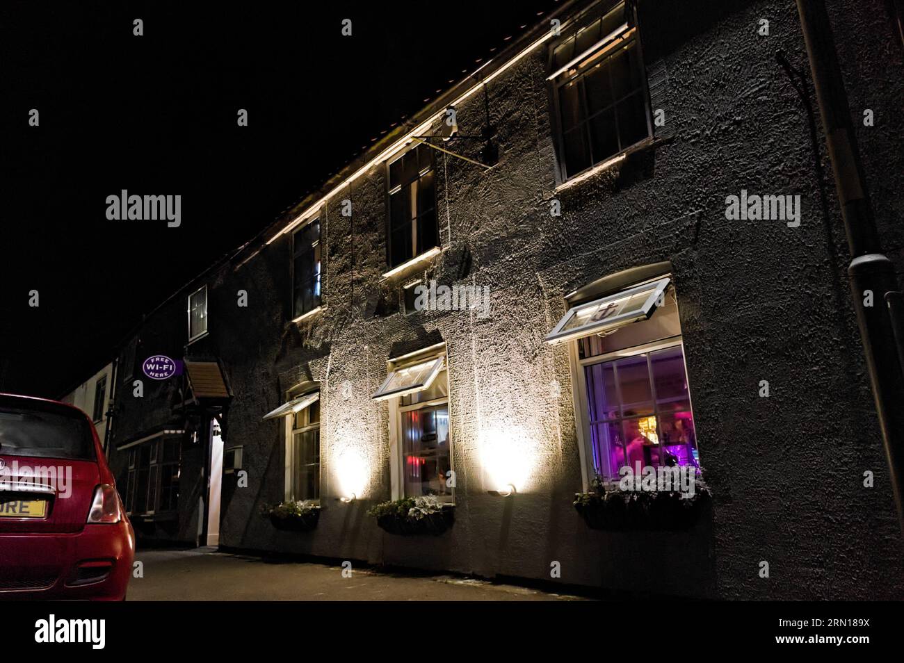 The Anchor Inn pub illuminated at night outside in the village Stock Photo
