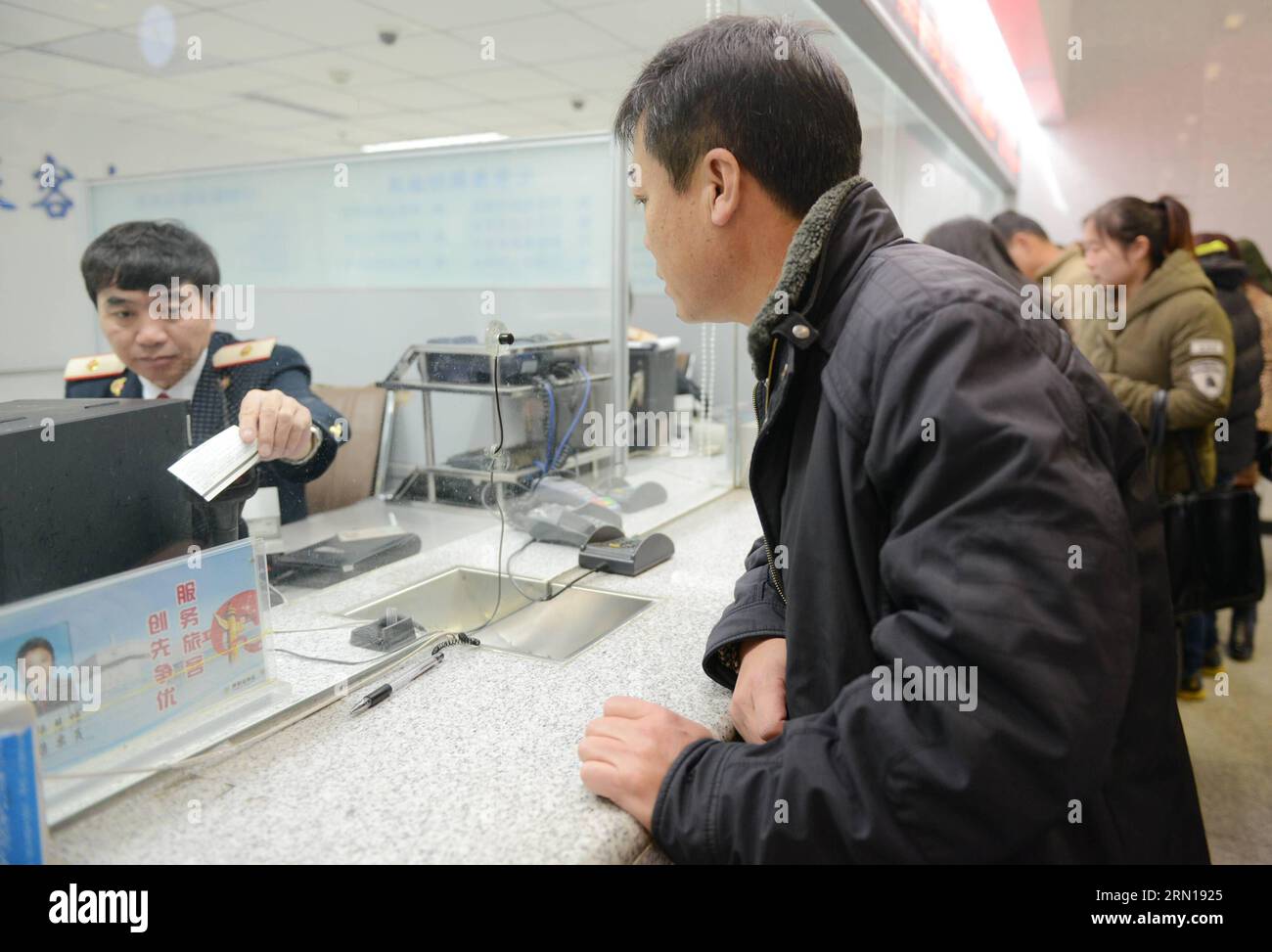 A passenger inquires about tickets at the ticket office of Hohhot Railway Station in Hohhot, north China s Inner Mongolia Autonomous Region, Dec. 7, 2014. China Railway Corporation (CRC), operator of China s rail network, started to sell train tickets for the 40-day travel period known as chunyun on Sunday . Chunyun , sometimes called the world s largest human migration, is the hectic travel period surrounding Chinese New Year. This year, chunyun will begin on Feb. 4 and last until March 16. ) (hdt) CHINA-RAILWAY-TICKET (CN) WangxJing PUBLICATIONxNOTxINxCHN   a Passenger Inquirer About Tickets Stock Photo