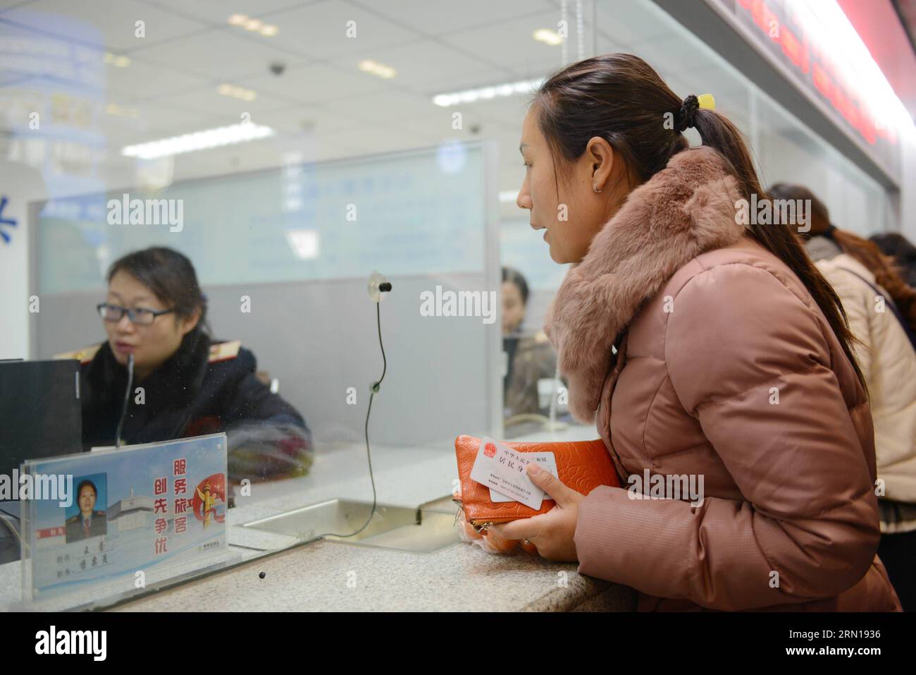 A passenger inquires about tickets at the ticket office of Hohhot Railway Station in Hohhot, north China s Inner Mongolia Autonomous Region, Dec. 7, 2014. China Railway Corporation (CRC), operator of China s rail network, started to sell train tickets for the 40-day travel period known as chunyun on Sunday . Chunyun , sometimes called the world s largest human migration, is the hectic travel period surrounding Chinese New Year. This year, chunyun will begin on Feb. 4 and last until March 16. ) (hdt) CHINA-RAILWAY-TICKET (CN) WangxJing PUBLICATIONxNOTxINxCHN   a Passenger Inquirer About Tickets Stock Photo