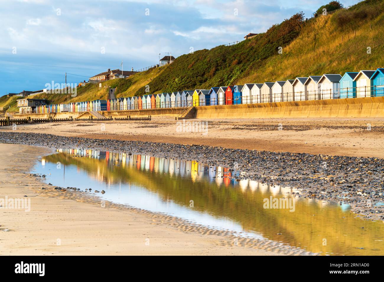 Relections of the beach huts on the beach at Mundesley in North Norfolk, UK at Sunrise Stock Photo