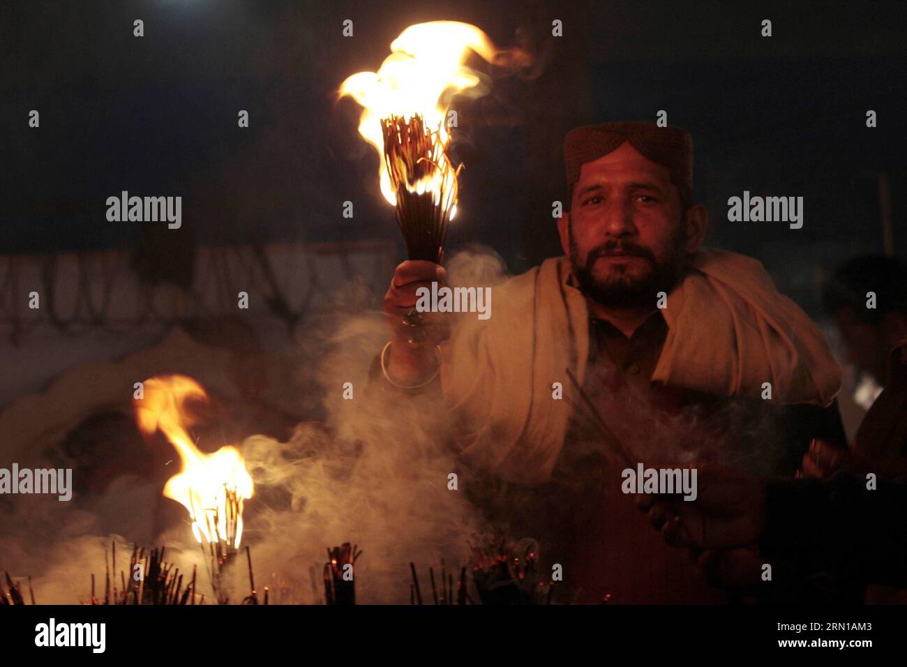 (141212) LAHORE, A Pakistani Muslim devotee holds candles at the