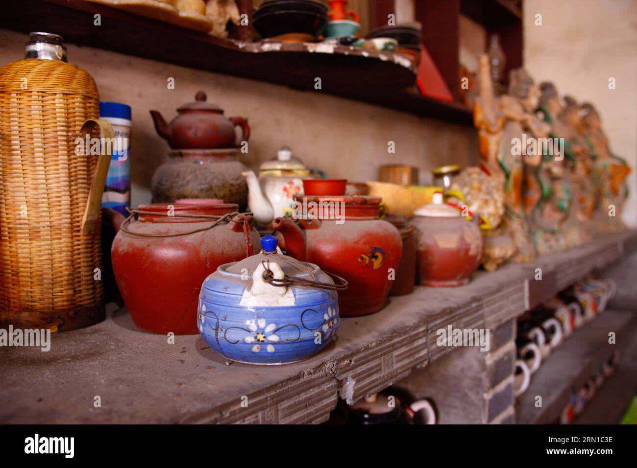 Old tea pots are seen in an old tea house in Linhuan Town, Suixi County of Huaibei City, east China s Anhui Province, Dec.11, 2014. Linhuan Town, located in the southwest of Suixi County of Huaibei City in east China s Anhui Province, has a long history that can dates back to more than four thousand years ago. Local people of Linhuan has kept the tradition of drinking tea since Ming Dynasty, which leaves its print on people s life here through the old square table, the rough sand bowl and the rusty copper tea pot. Customers usually show up at the tea house at ten in the morning, where they can Stock Photo