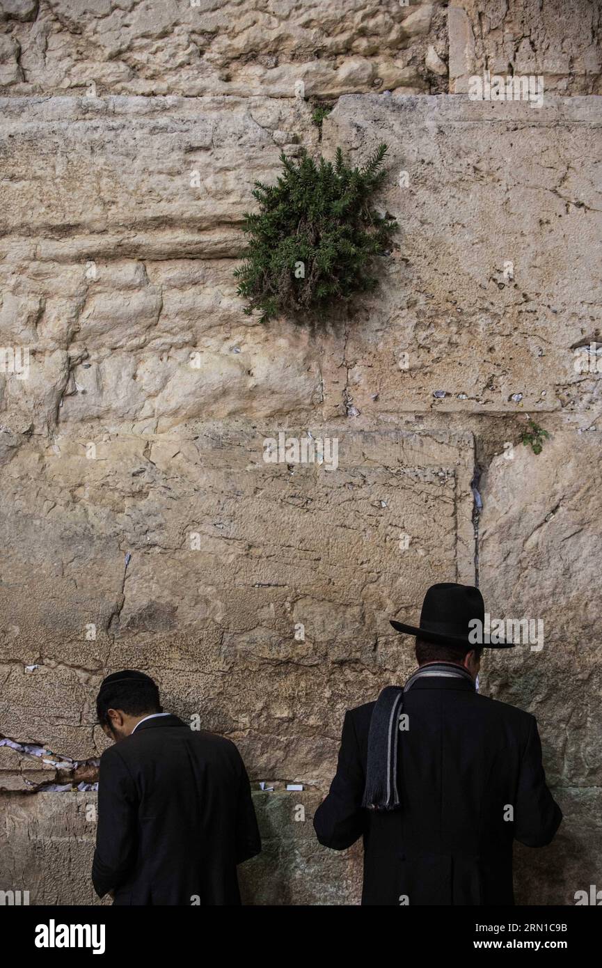 JERUSALEM, Dec. 16, 2014 -- Ultra-Orthodox Jewish men pray to mark Hanukkah at the Western Wall in the Old City of Jerusalem, on Dec. 16, 2014. Hanukkah, also known as the Festival of Lights and Feast of Dedication, is an eight-day Jewish holiday commemorating the rededication of the Holy Temple (the Second Temple) in Jerusalem at the time of the Maccabean Revolt against the Seleucid Empire of the 2nd Century B.C. Hanukkah is observed for eight nights and days, starting on the 25th day of Kislev according to the Hebrew calendar, which may occur at any time from late November to late December. Stock Photo