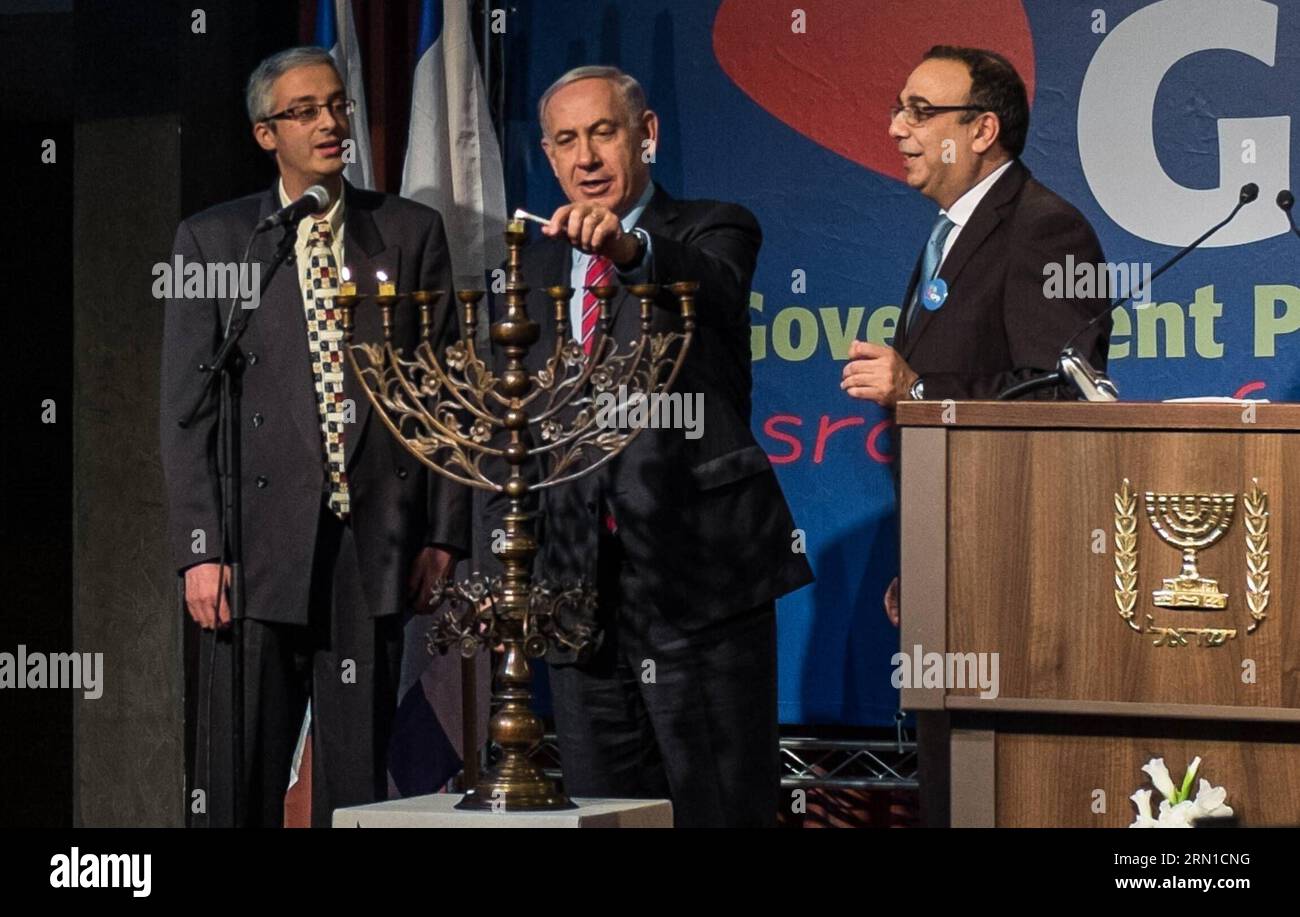 JERUSALEM,  Israeli Prime Minister Benjamin Netanyahu (C) lights candles on a Hannukiya to mark the second day of Hanukkah during the Government Press Office (GPO) annual reception at the Israel Museum in Jerusalem, on Dec. 17, 2014. Hanukkah entered the second day on Wednesday. Hanukkah, also known as the Festival of Lights and Feast of Dedication, is an eight-day Jewish holiday commemorating the rededication of the Holy Temple (the Second Temple) in Jerusalem at the time of the Maccabean Revolt against the Seleucid Empire of the 2nd Century B.C. Hanukkah is observed for eight nights and days Stock Photo