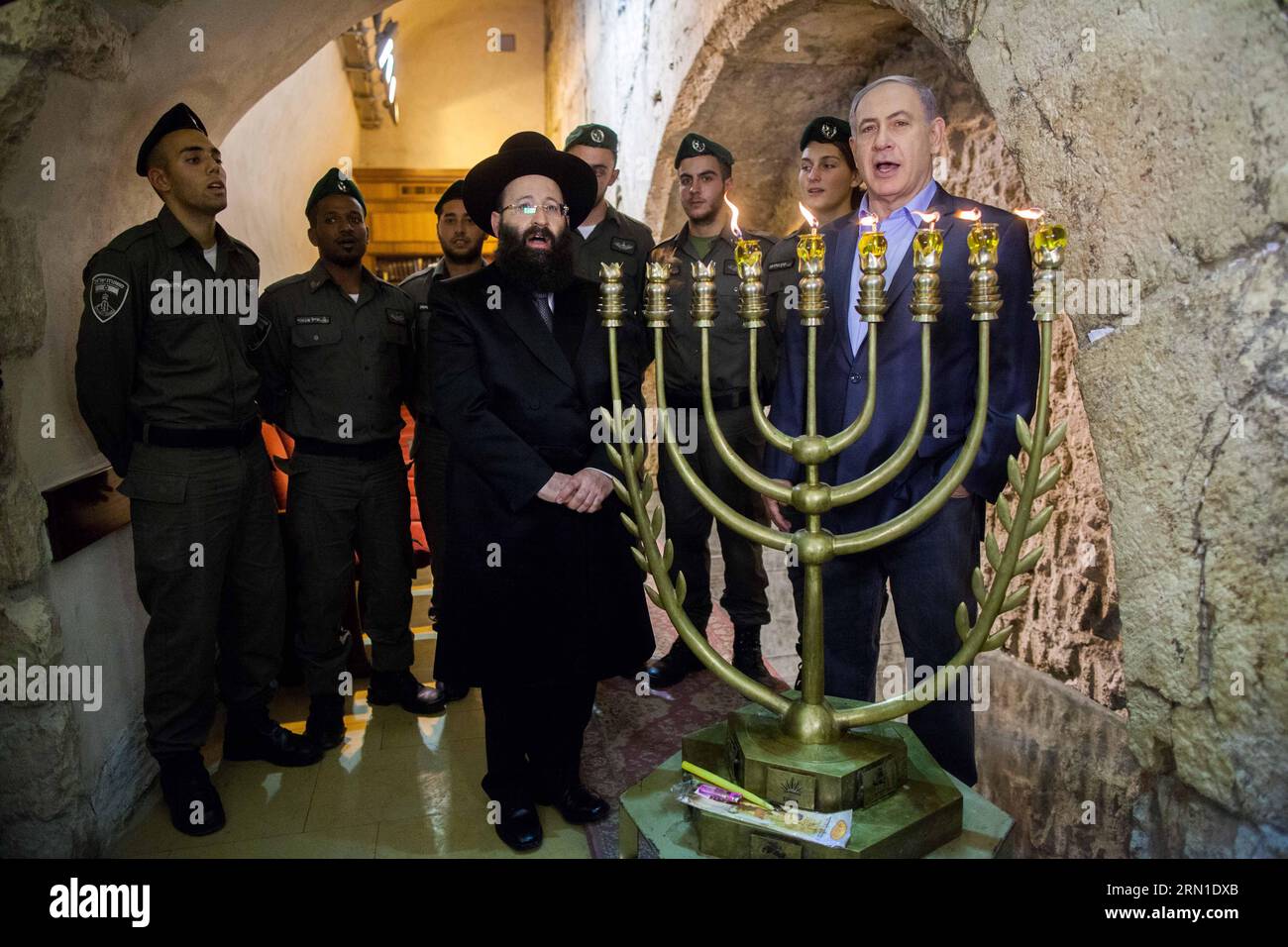 Israeli Prime Minister Benjamin Netanyahu (1st R)attends a ceremony to mark the fifth night of Hanukkah at the Western Wall in the Old City of Jerusalem, on Dec. 20, 2014. Hanukkah, also known as the Festival of Lights and Feast of Dedication, is an eight-day Jewish holiday commemorating the rededication of the Holy Temple (the Second Temple) in Jerusalem at the time of the Maccabean Revolt against the Seleucid Empire of the 2nd Century B.C. Hanukkah is observed for eight nights and days, starting on the 25th day of Kislev according to the Hebrew calendar, which may occur at any time from late Stock Photo