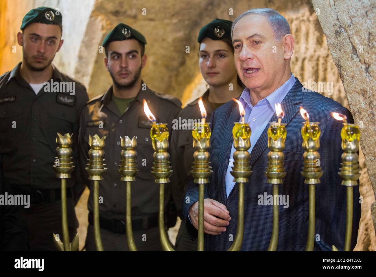 Israeli Prime Minister Benjamin Netanyahu (1st R) attends a ceremony to mark the fifth night of Hanukkah at the Western Wall in the Old City of Jerusalem, on Dec. 20, 2014. Hanukkah, also known as the Festival of Lights and Feast of Dedication, is an eight-day Jewish holiday commemorating the rededication of the Holy Temple (the Second Temple) in Jerusalem at the time of the Maccabean Revolt against the Seleucid Empire of the 2nd Century B.C. Hanukkah is observed for eight nights and days, starting on the 25th day of Kislev according to the Hebrew calendar, which may occur at any time from lat Stock Photo