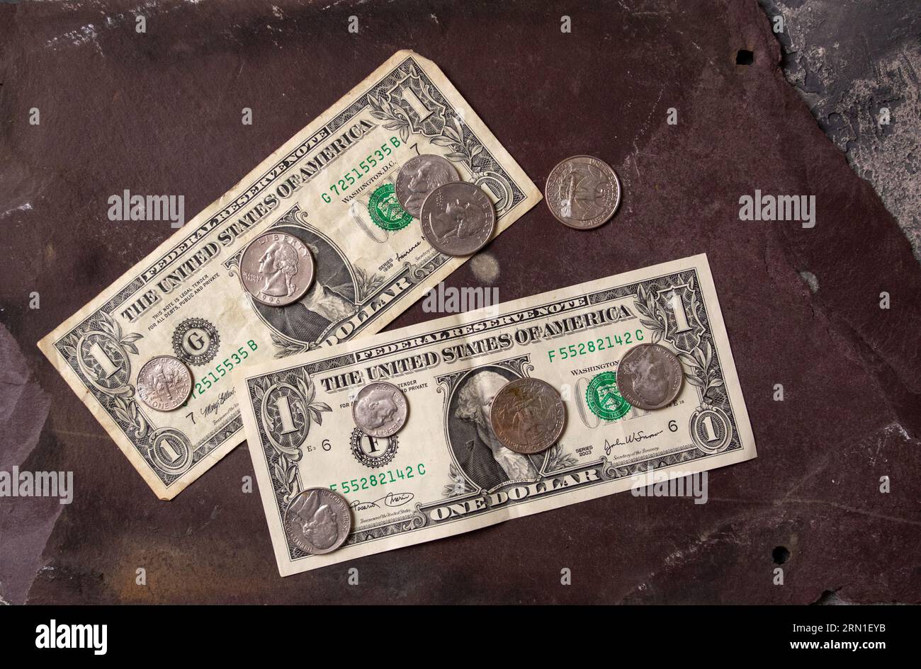 Two one dollar bills face up showing George Washington America's first president and assorted coins Stock Photo