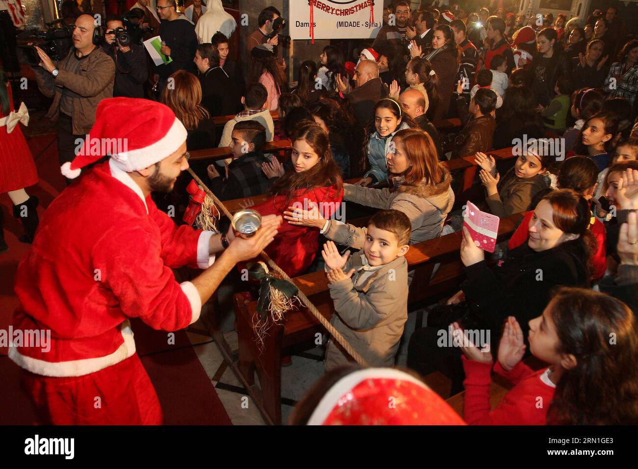 (141230) -- DAMASCUS, Dec. 30, 2014 -- People watch the performance during the Christmas celebration at al-Zaitoun Cathedral in Damascus, capital of Syria, on Dec. 30, 2014. About 1,500 Syrian Christian kids and their parents gathered at al-Zaitoun Cathedral in Syria s capital Damascus to take part in a Christmas celebration. About 10 percent of population in Syria are Christian, who suffered persecution in some parts of the country by the hands of the extremist groups. )(zhf) SYRIA-DAMASCUS-CHRISTIAN-CHRISTMAS CELEBRATION bassemxtellawi PUBLICATIONxNOTxINxCHN   Damascus DEC 30 2014 Celebritie Stock Photo
