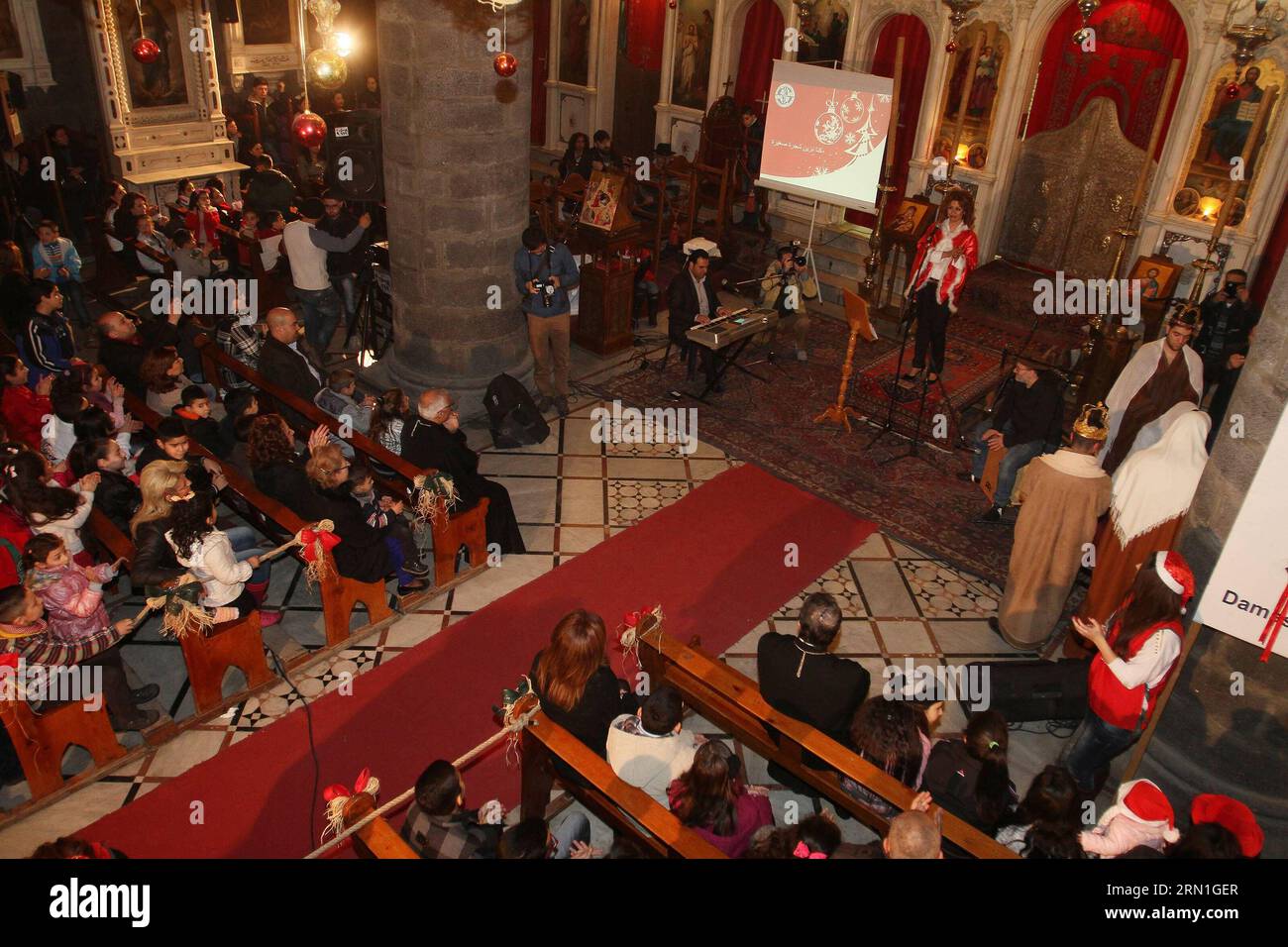 (141230) -- DAMASCUS, Dec. 30, 2014 -- People watch the performance during the Christmas celebration at al-Zaitoun Cathedral in Damascus, capital of Syria, on Dec. 30, 2014. About 1,500 Syrian Christian kids and their parents gathered at al-Zaitoun Cathedral in Syria s capital Damascus to take part in a Christmas celebration. About 10 percent of population in Syria are Christian, who suffered persecution in some parts of the country by the hands of the extremist groups. )(zhf) SYRIA-DAMASCUS-CHRISTIAN-CHRISTMAS CELEBRATION bassemxtellawi PUBLICATIONxNOTxINxCHN   Damascus DEC 30 2014 Celebritie Stock Photo