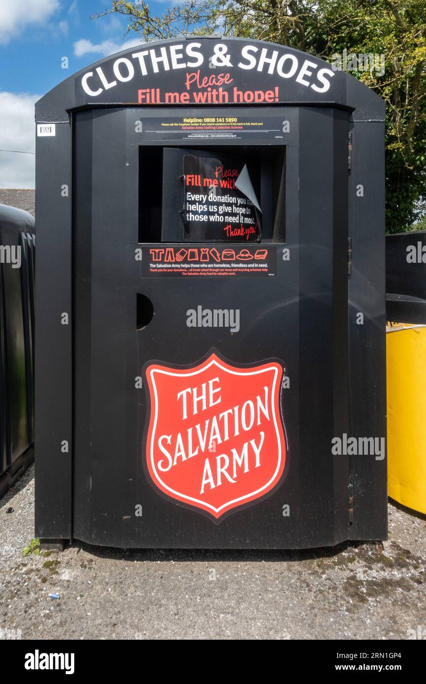 Salvation Army recycling and reuse bin to collect clothes and shoes for homeless charity, village recycling area, England, UK Stock Photo