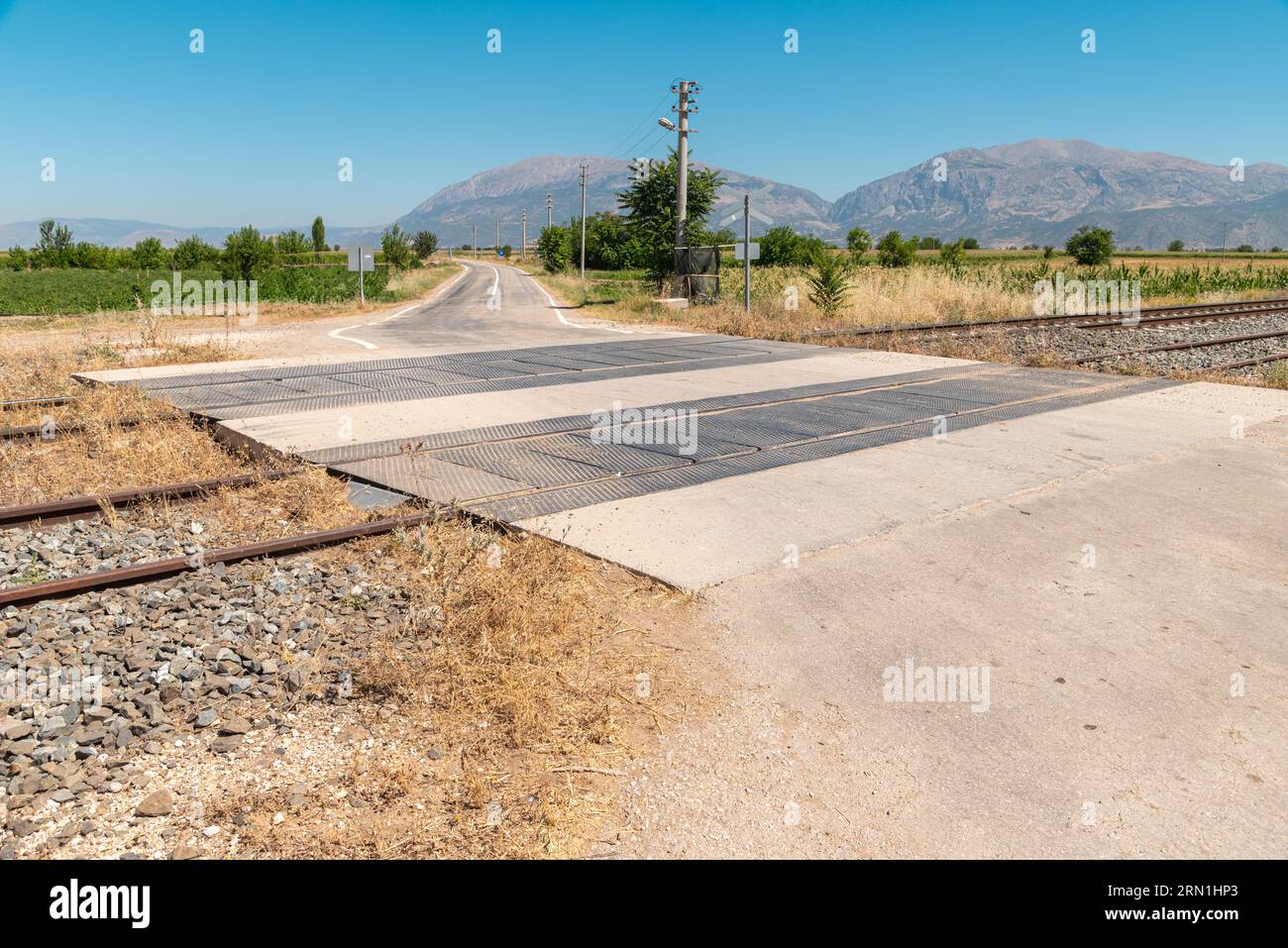 Unguarded, light rail railway crossing without barriers and warning lights Stock Photo