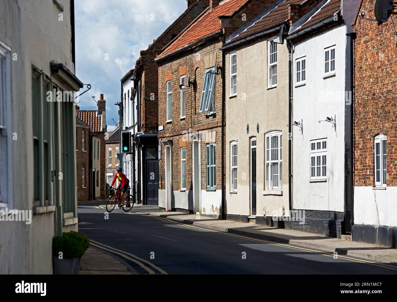 Cyclist negotiating a corner in the village of Cawood, North Yorkshire, England UK Stock Photo
