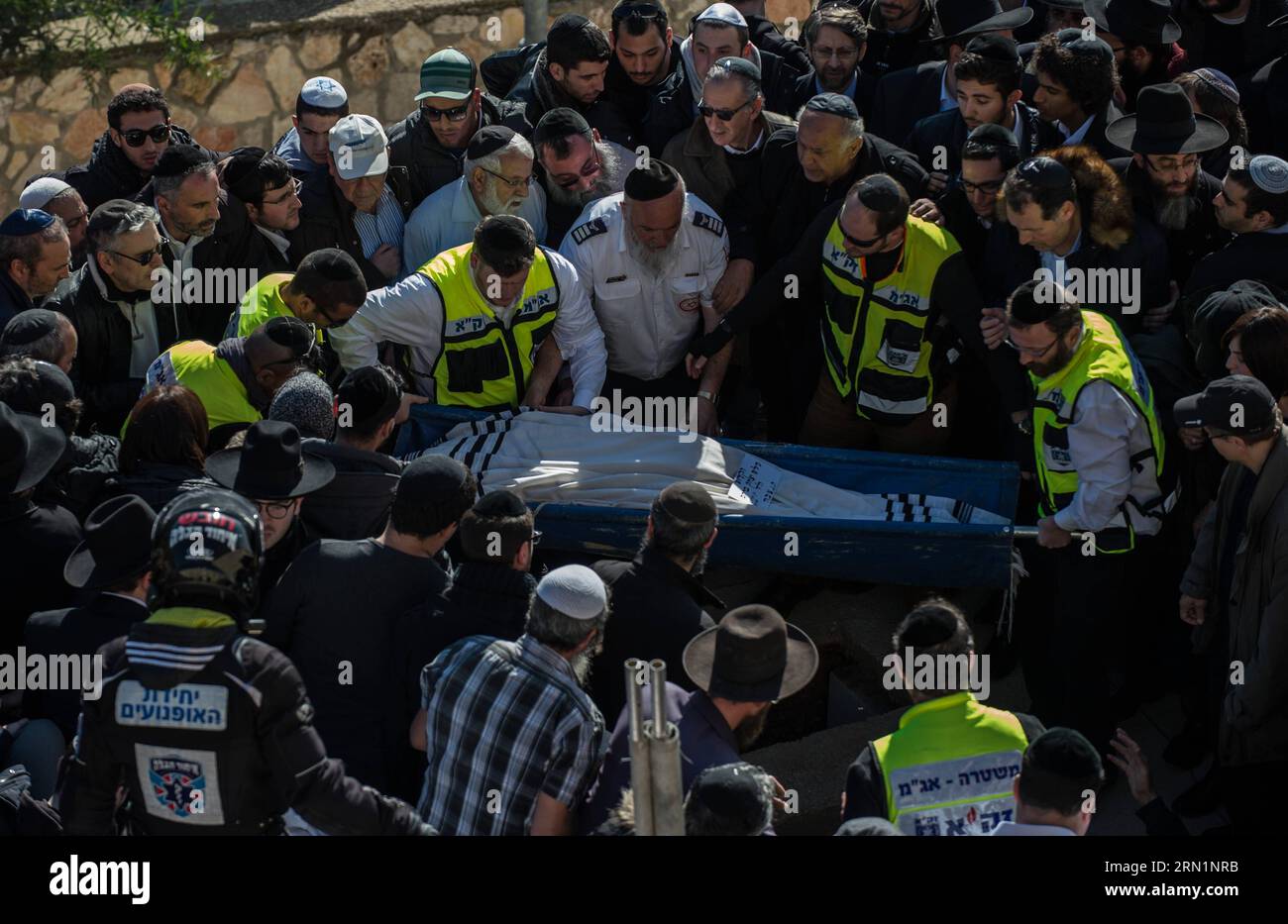 (150113) -- JERUSALEM, Jan. 13, 2015 -- A body of victim of Paris supermarket attack is carried to the grave during a funeral ceremony at Givat Shaul cemetery, on the outskirts of Jerusalem, on Jan. 13, 2015. Israeli leaders and multitude of mourners gathered Tuesday with the families of four Jewish victims of last week s terror attack on a Paris kosher supermarket for a solemn funeral ceremony at a Jerusalem cemetery. Yoav Hattab, Yohan Cohen, Philippe Braham and Francois-Michel Saada, were gunned down on Friday during a hostage attack on Hyper Casher supermarket in eastern Paris. They were a Stock Photo